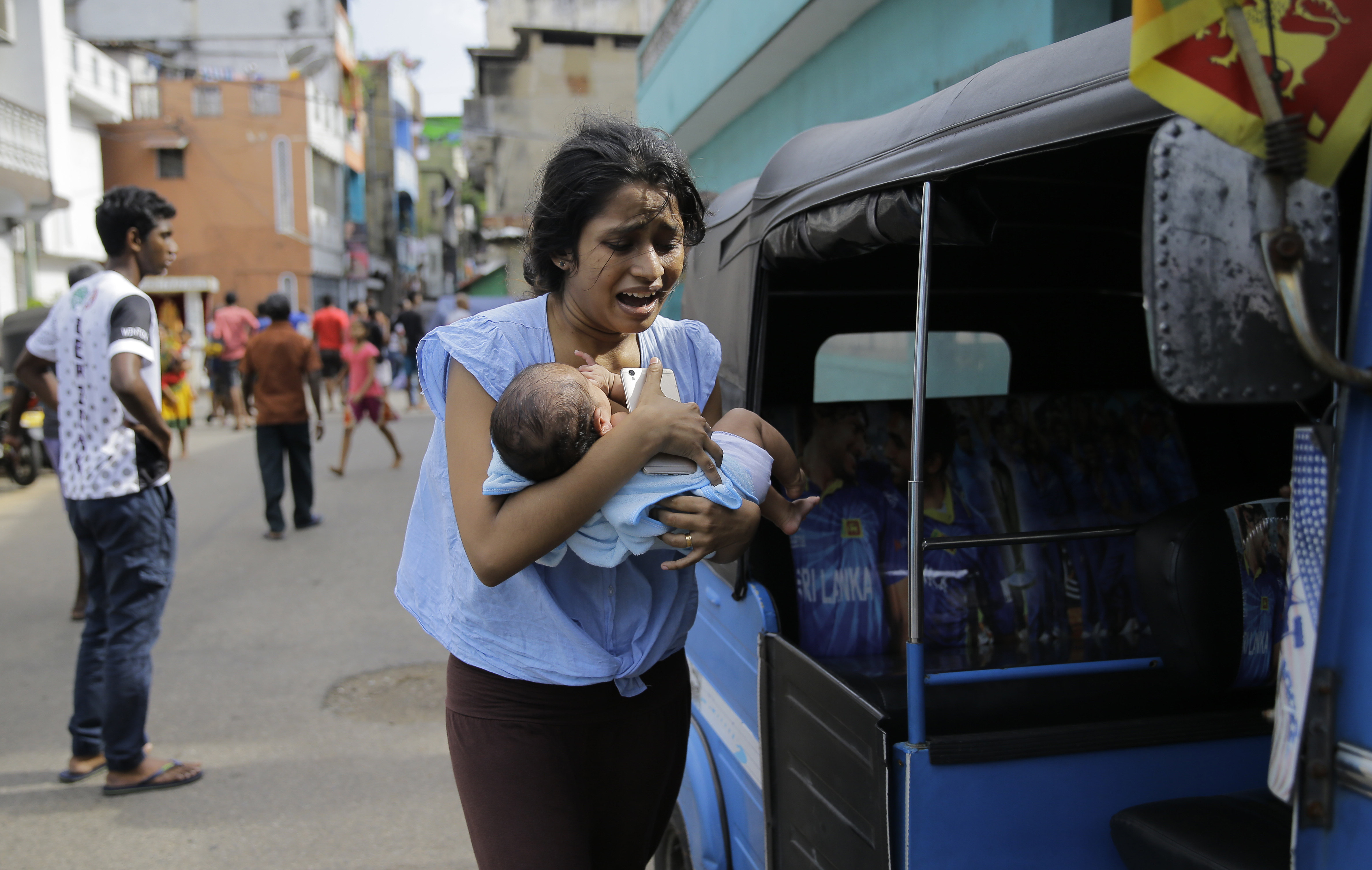 1555949339960-AP_19112432164428A Sri Lankan woman living near St. Anthony's shrine runs for safety with her infant after police found explosive devices in a parked vehicle in Colombo, Sri Lanka, Monday, April 22, 2019. Easter Sunday bombings that ripped through churches and luxury hotels killed more than 200 people. (AP Photo/Eranga Jayawardena)