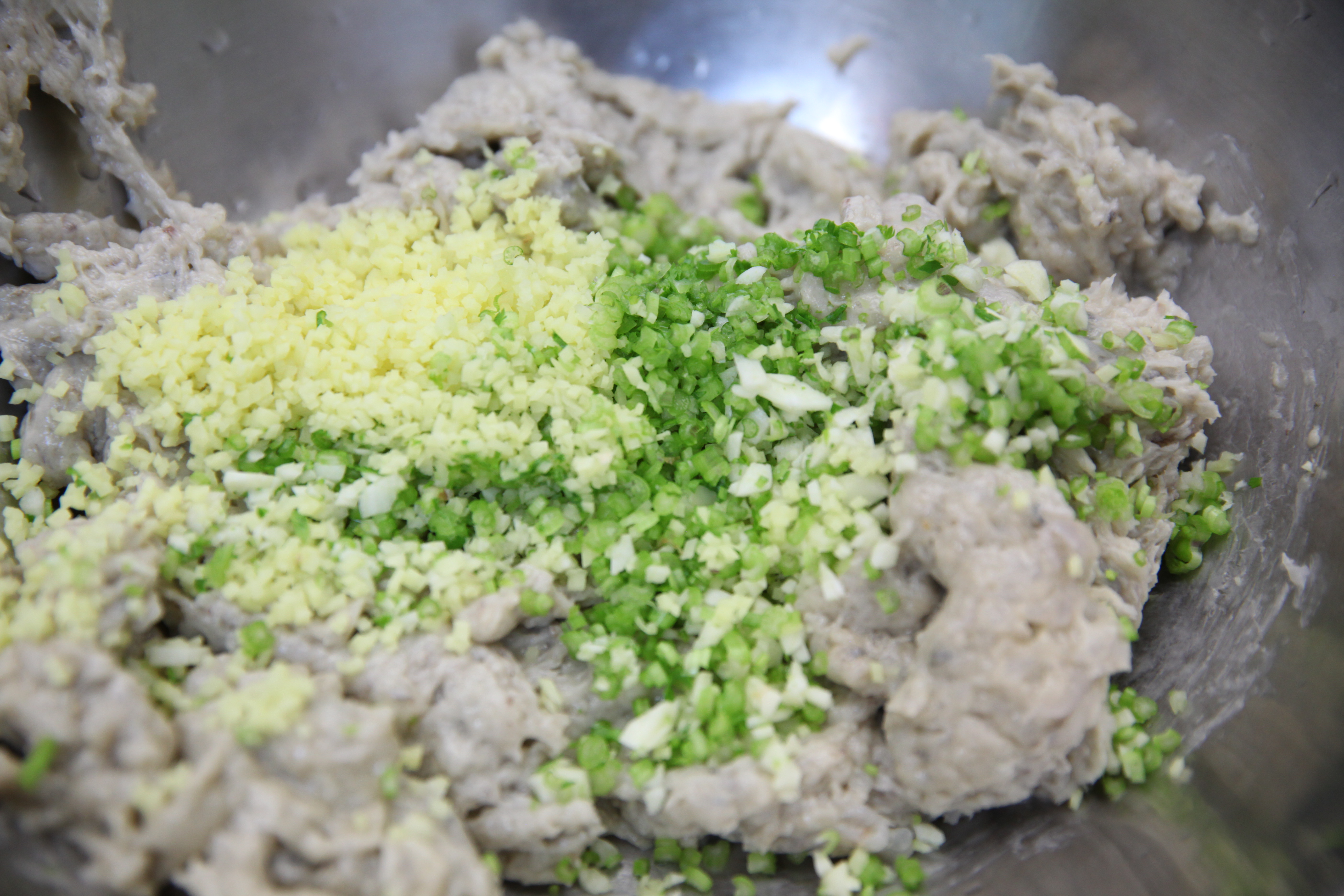 a paste of shrimp, cilantro stems, and minced ginger in a bowl for chef mei lin's shrimp toast