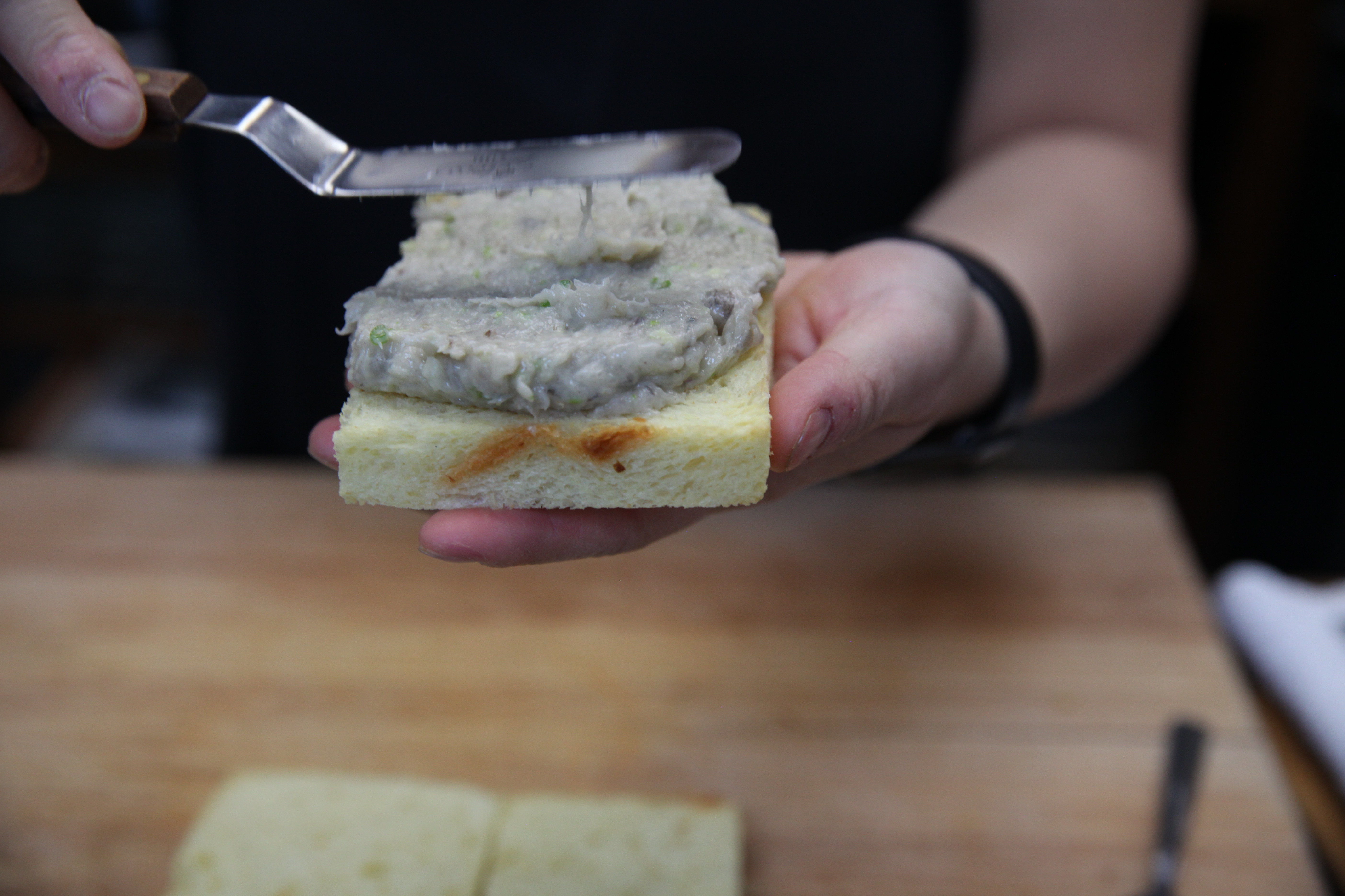 chef mei lin spreading shrimp toast mixture onto toast