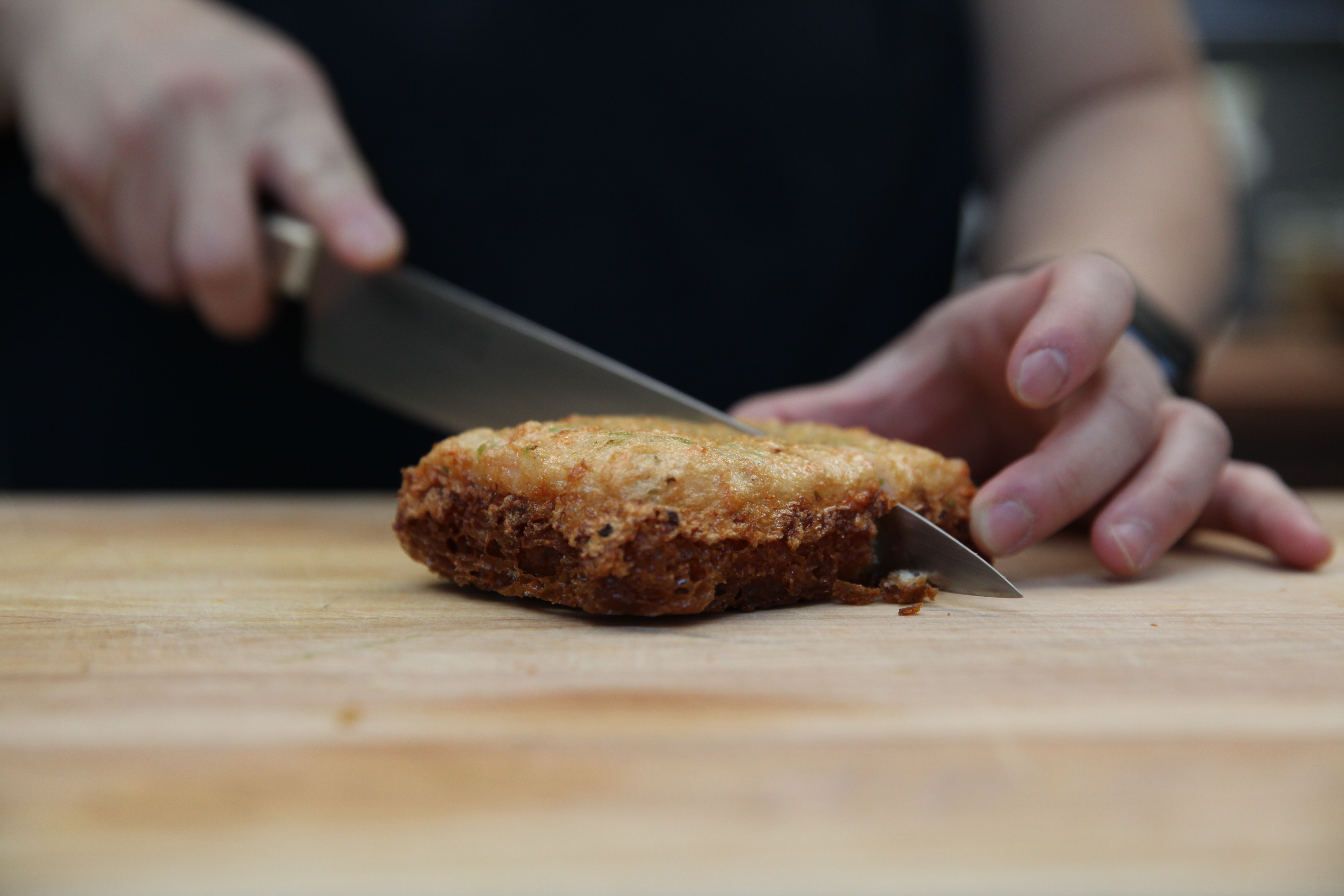 chef mei lin slicing a piece of shrimp toast