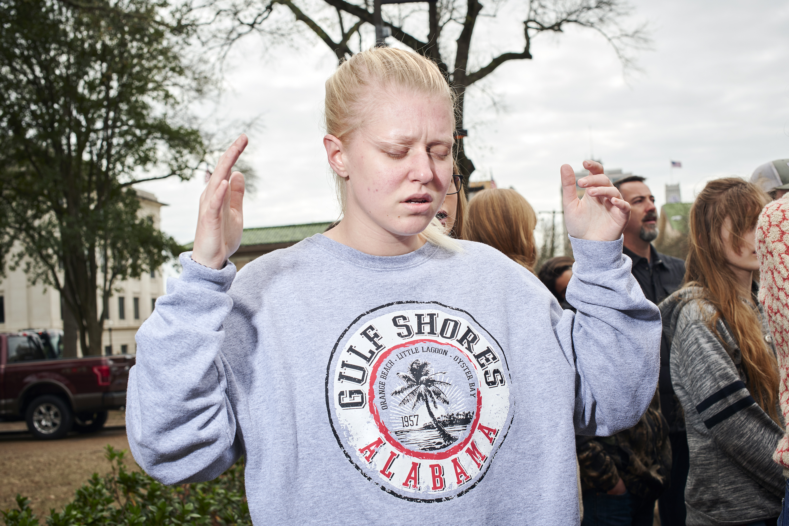 A girl prays while Thomas preaches outside the Capitol. Photo by Finlay MacKay.