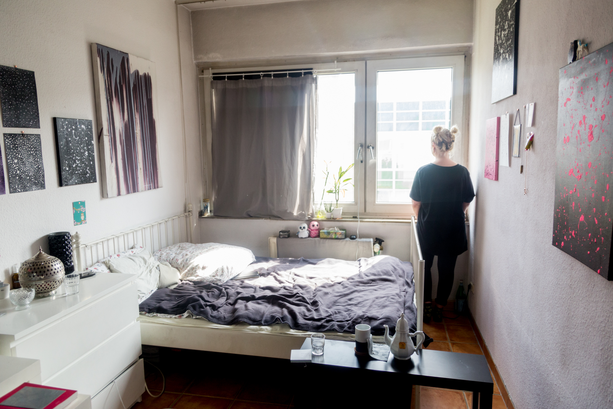 Elisa steht am Fenster ihres WG-Zimmers