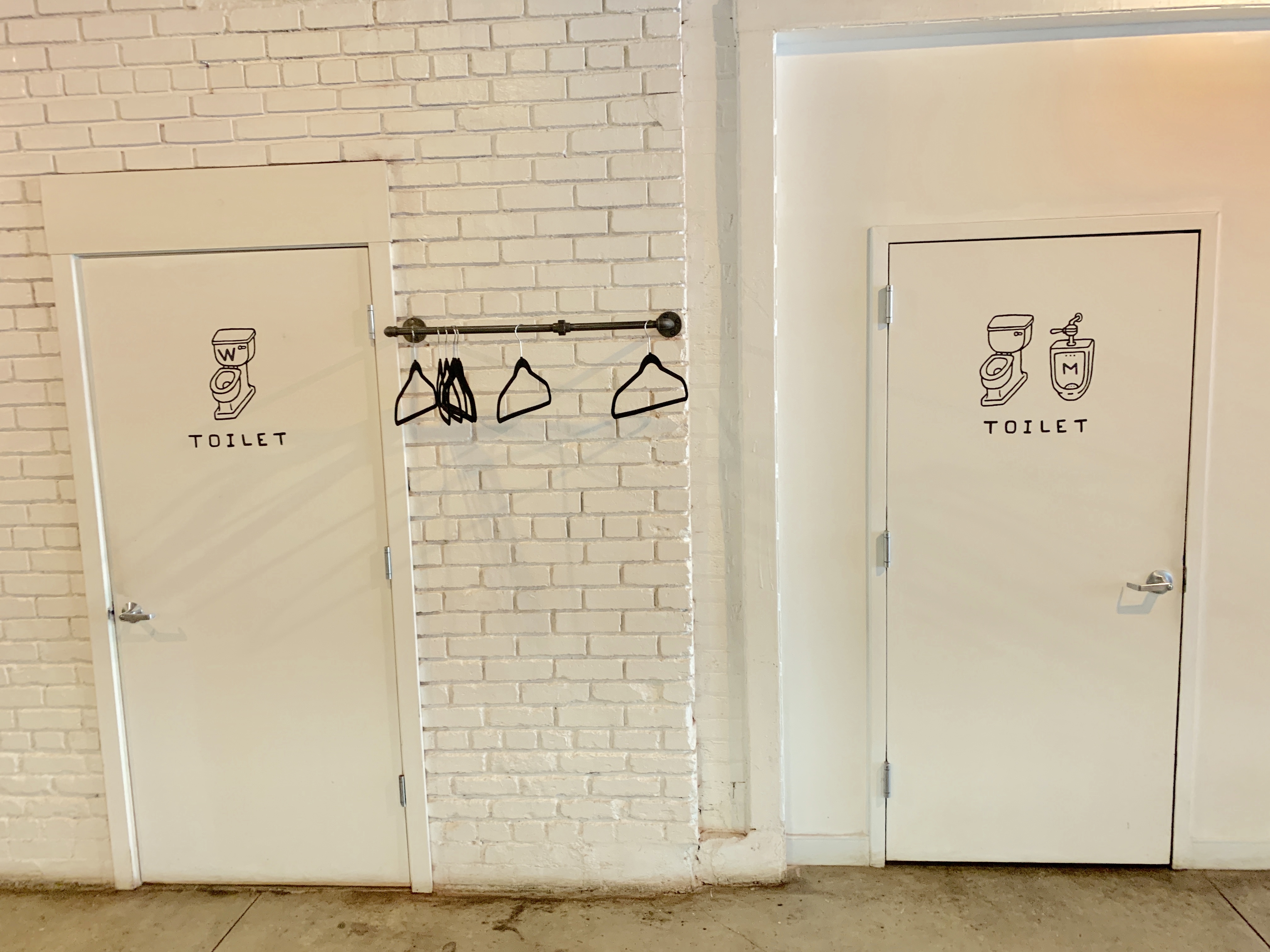 the after picture of the bathrooms at good company in cleveland, ohio, with M and W labels added to the toilet illustrations on each door