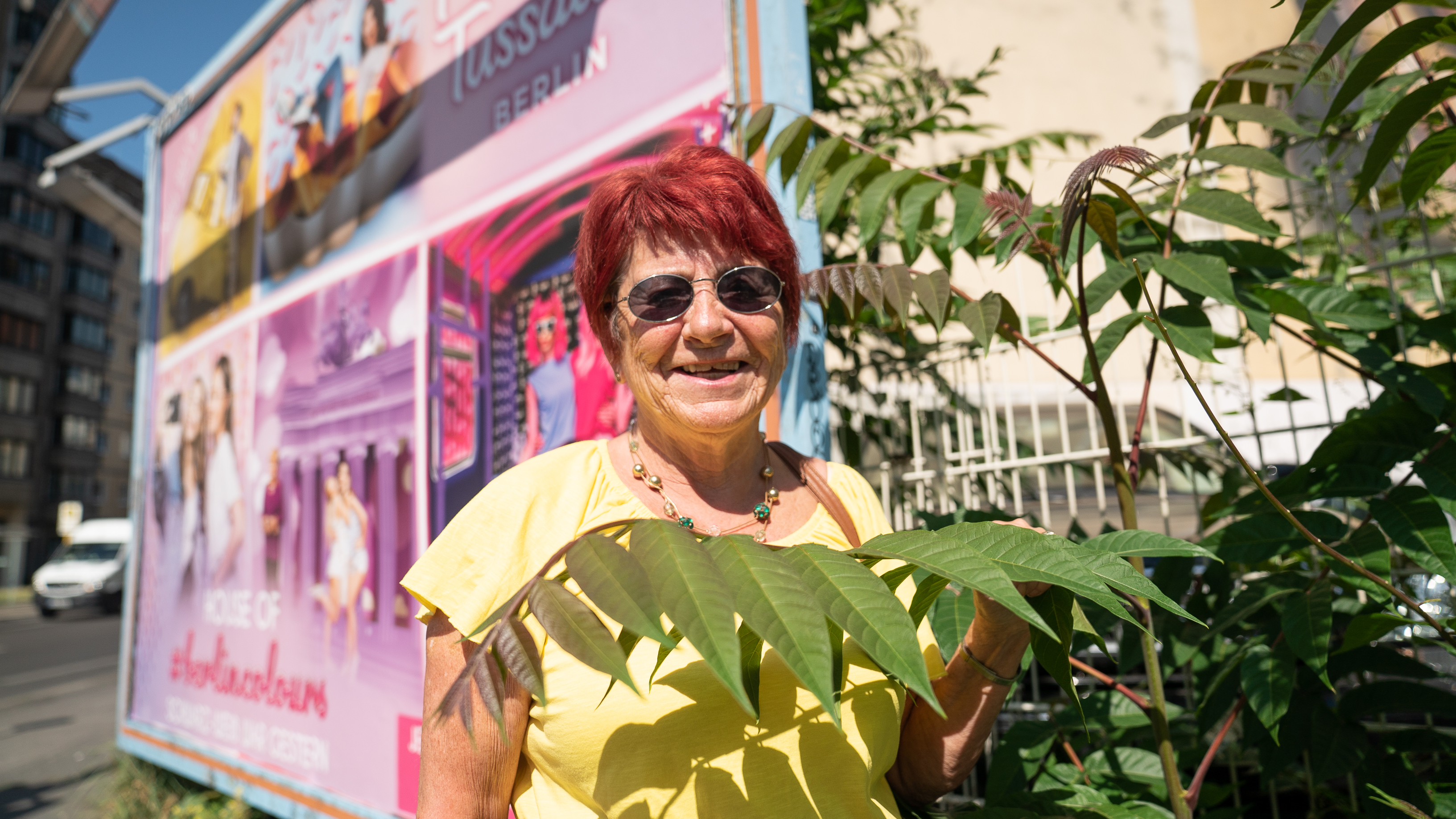 Eine Frau mit roten Haaren steht vor einer Wand
