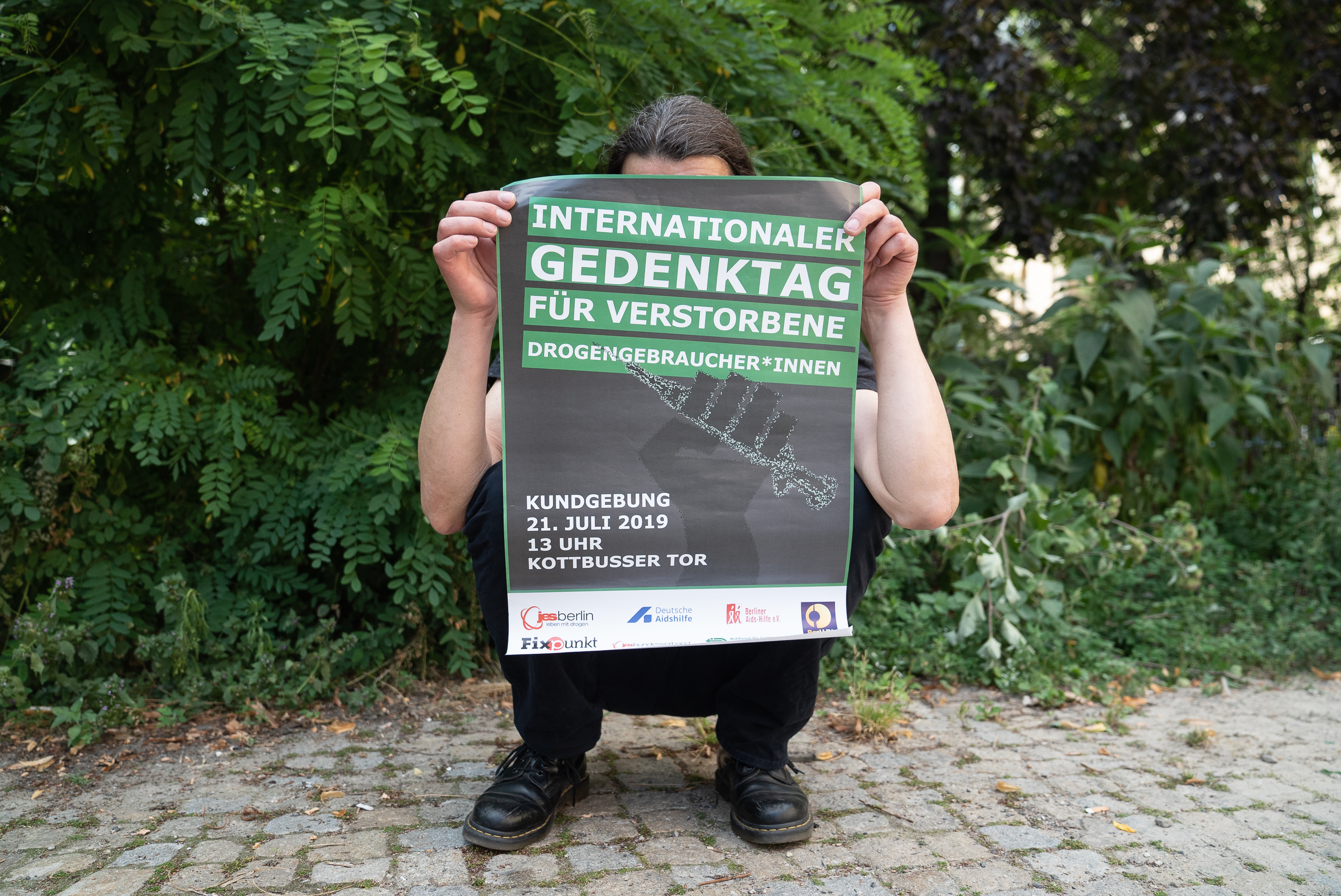 Andreas mit dem Poster für den Internationalen Gedenktag für Verstorbene Drogengebraucher*innen