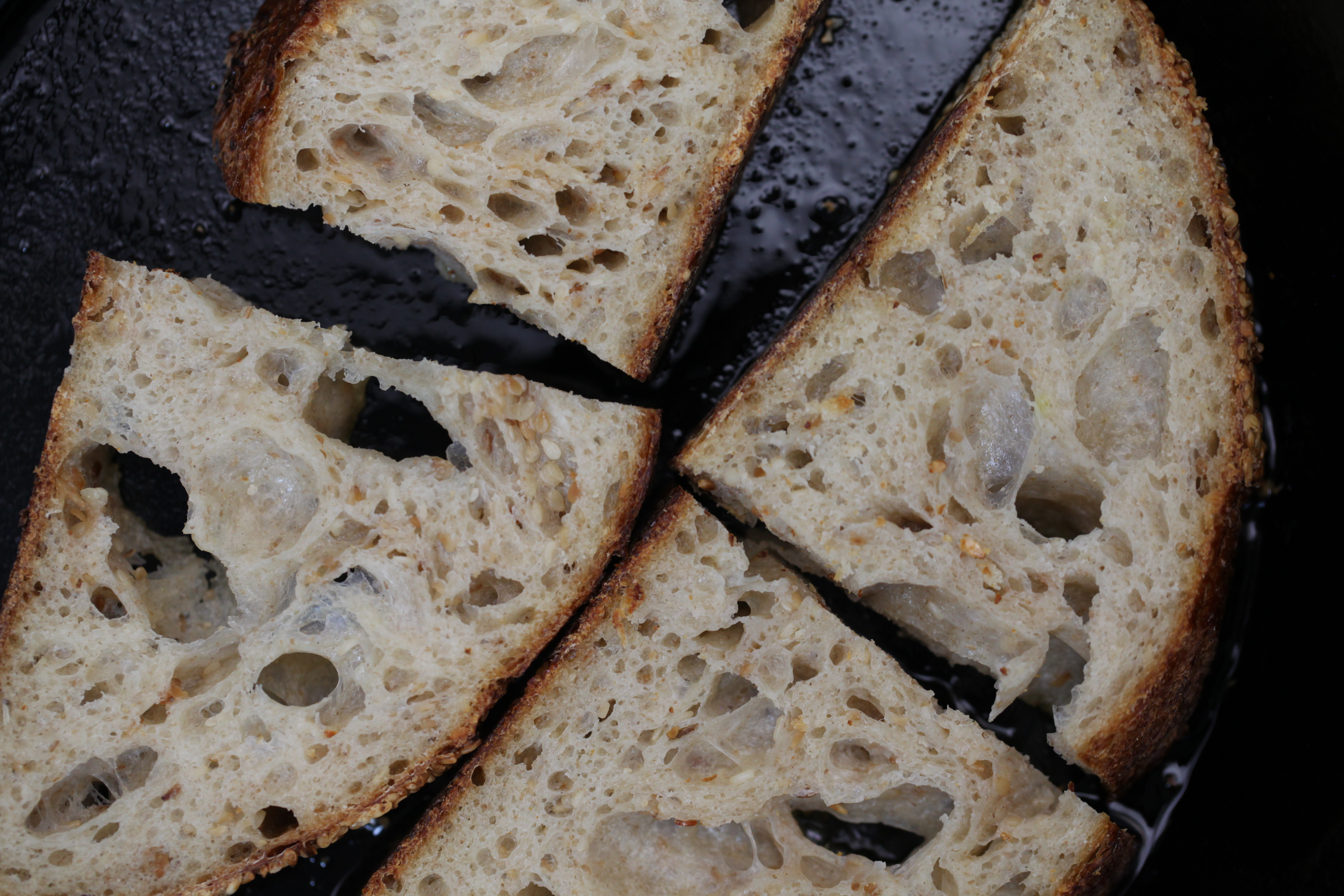 slices of sourdough bread from gertie in brooklyn, toasting in a cast iron pan