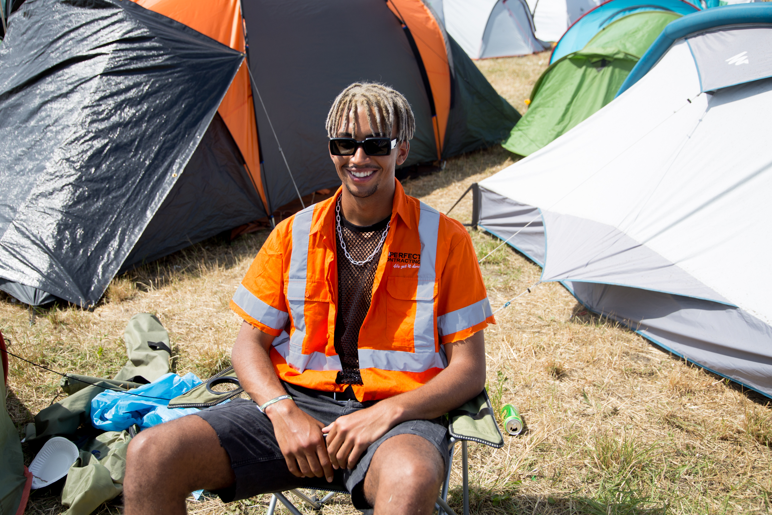 Ein Mann in Warnweste sitzt auch einem Campingstuhl