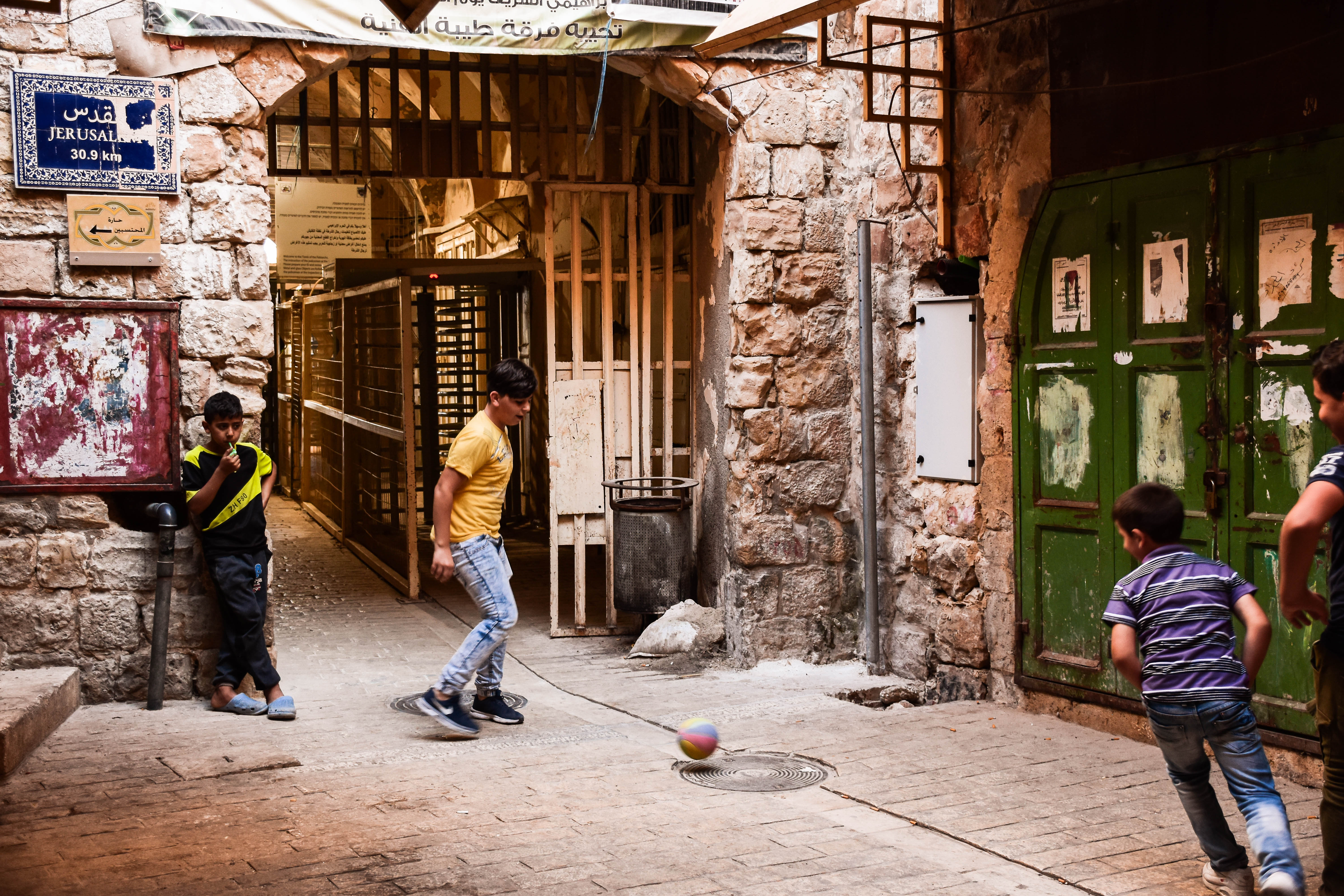 1564670378579-Bambini-palestinesi-mente-giocano-a-calcio-davanti-ad-uno-dei-diciotto-check-point-presenti-nella-citta-vecchia-di-Al-khalil
