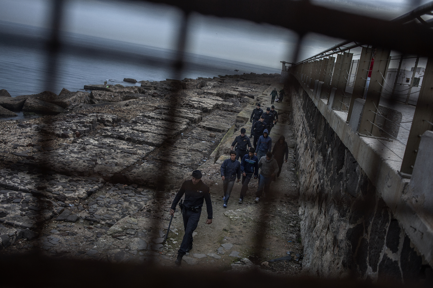 The Civil Guard stopping a child climbing the wall at the port of Melilla, in 2014