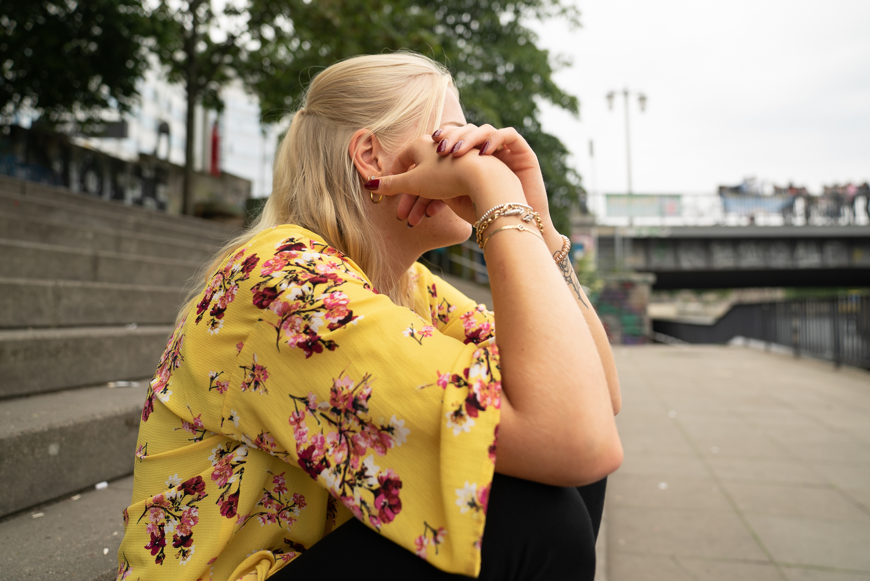 eine blonde frau sitzt auf einer treppe