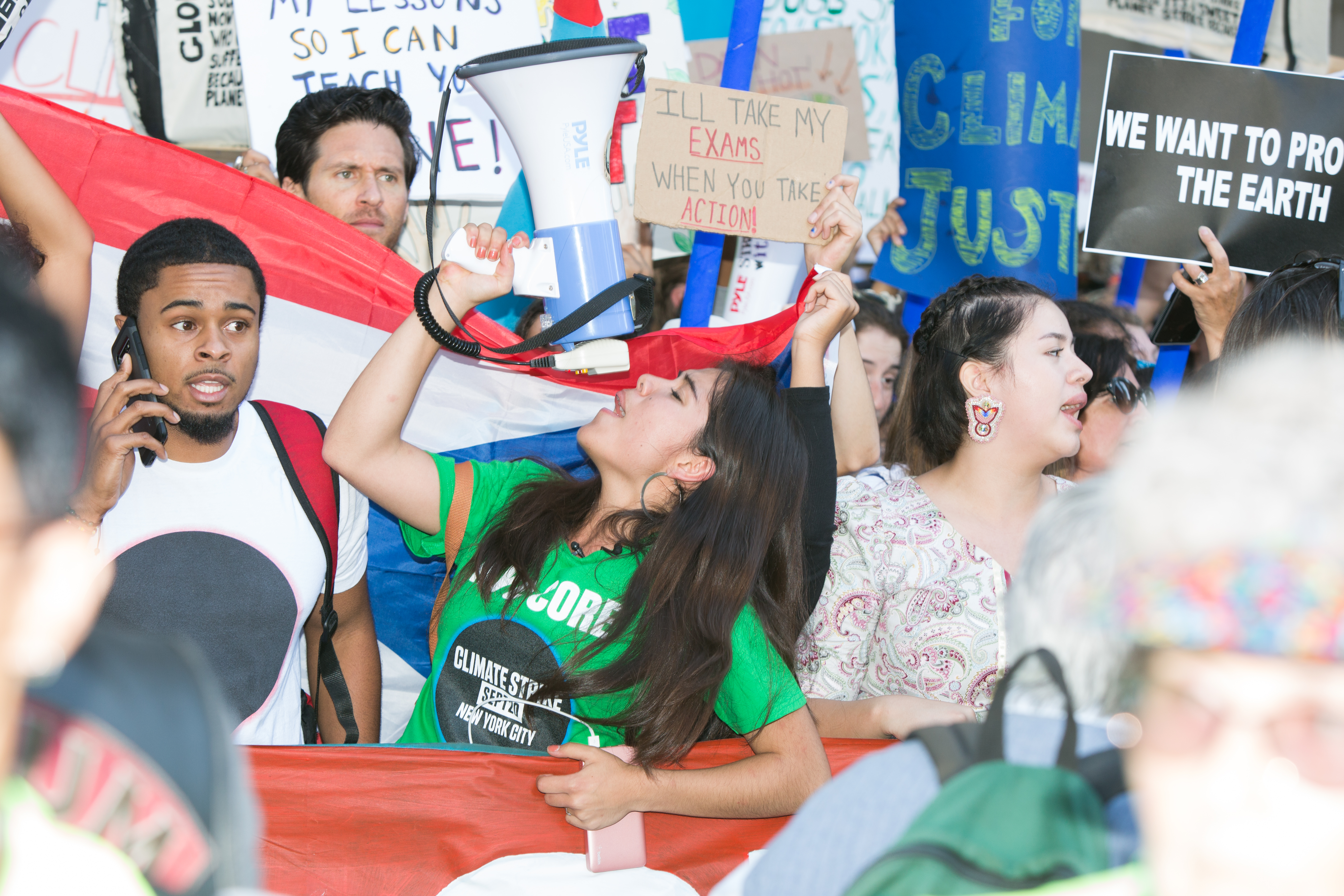 A young climate protester holds a megaphone.