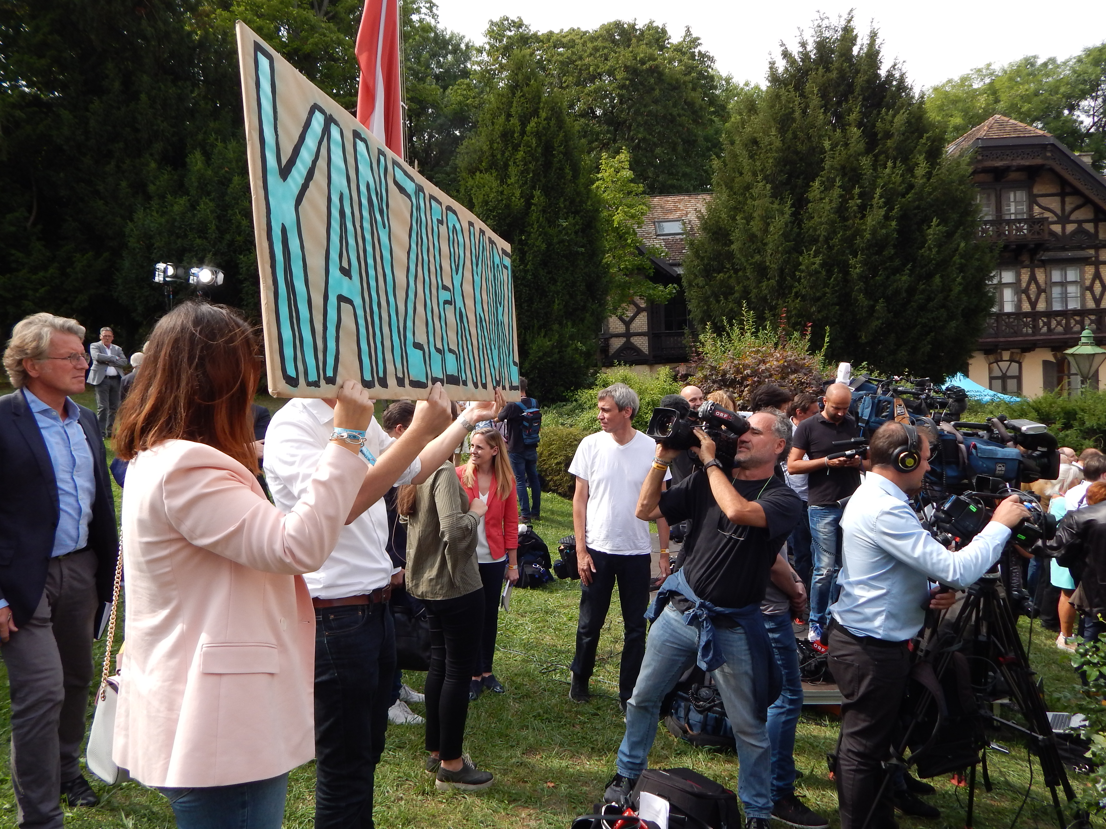 Ein Sebastian-Kurz-Schild wird in die Kameras gehalten