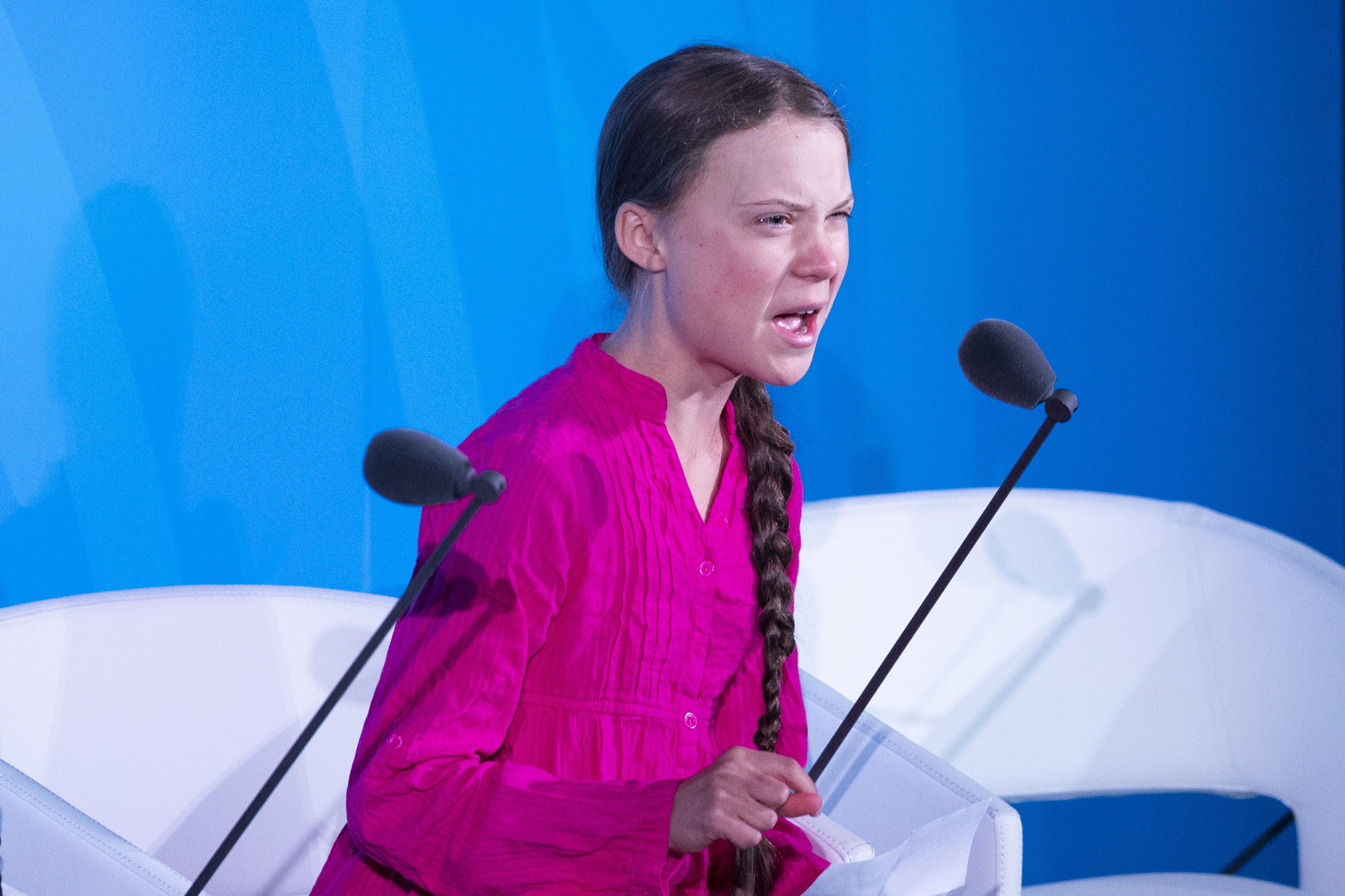 Greta Thunberg speaks into a microphone onstage at the United Nations.