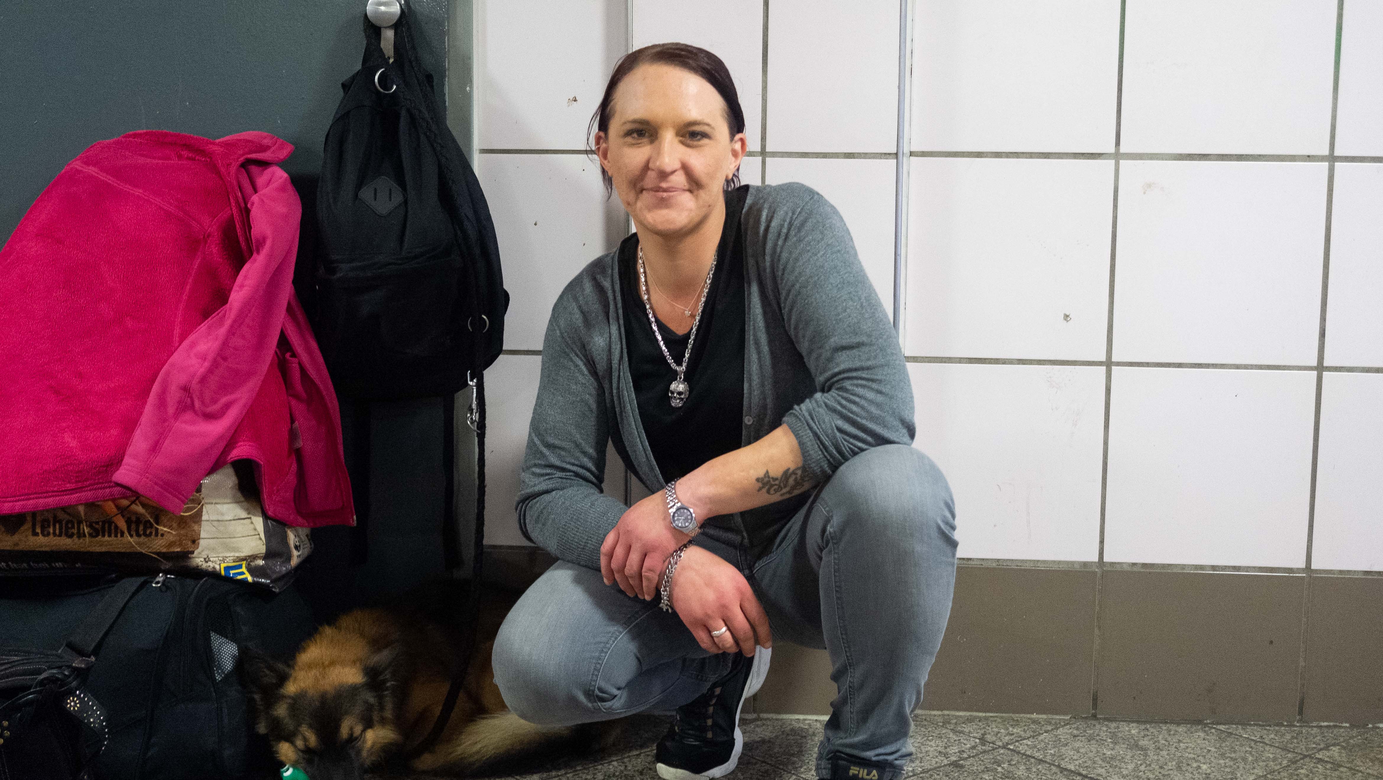 Eine Frau neben ihrem Hund in einer U-Bahnhaltestelle in Berlin
