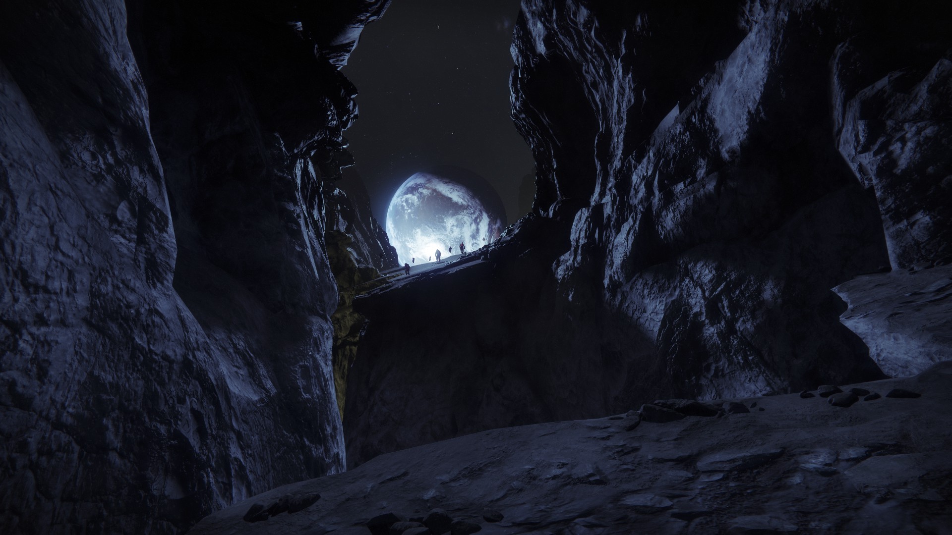 Screenshot from Destiny 2: Shadowkeep. A view from within a canyon on the Moon, the Earth framed by the canyon's walls. Ghostly figures float above a rocky outcropping in front of the Earth.