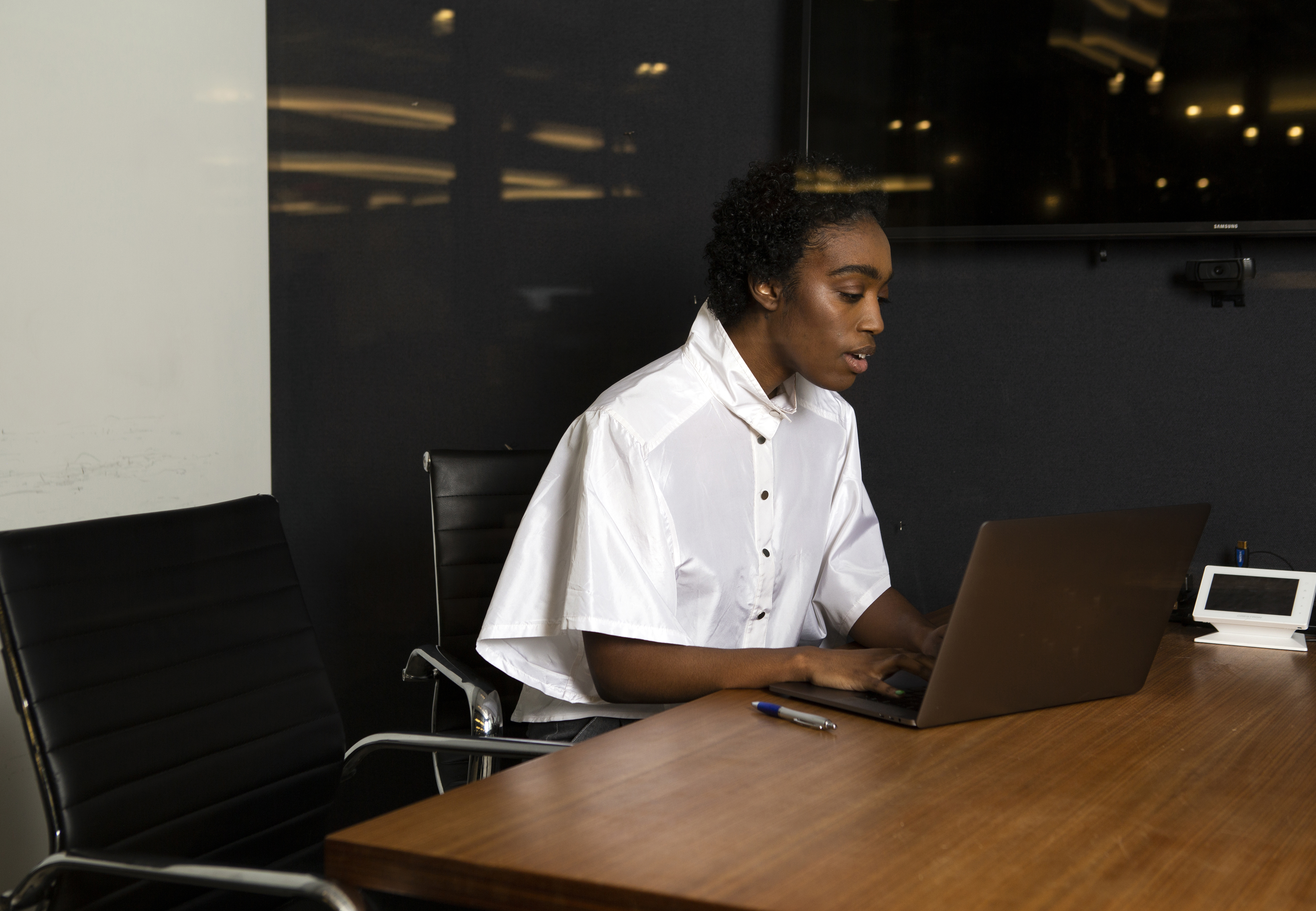 A non-binary person using a laptop at work