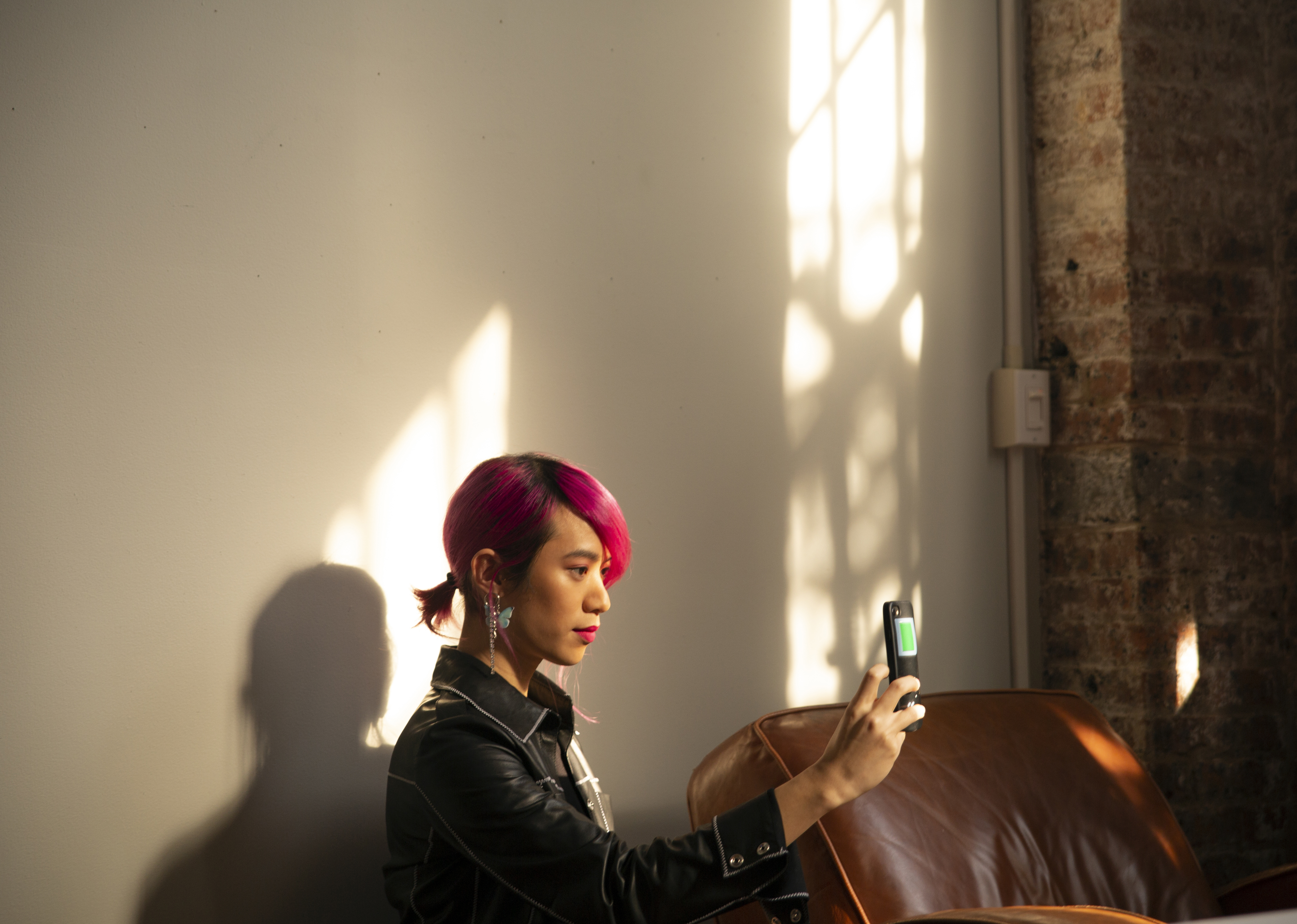 A non-binary femme using their phone