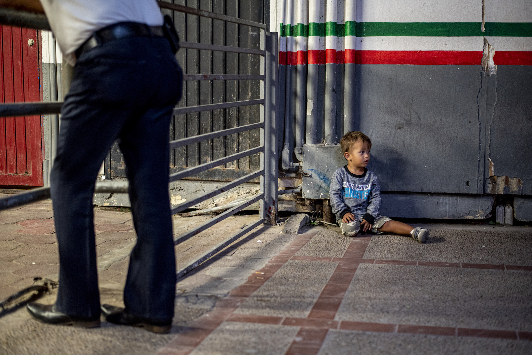 A boy sits near the border crossing. Photo by Sergio Flores.