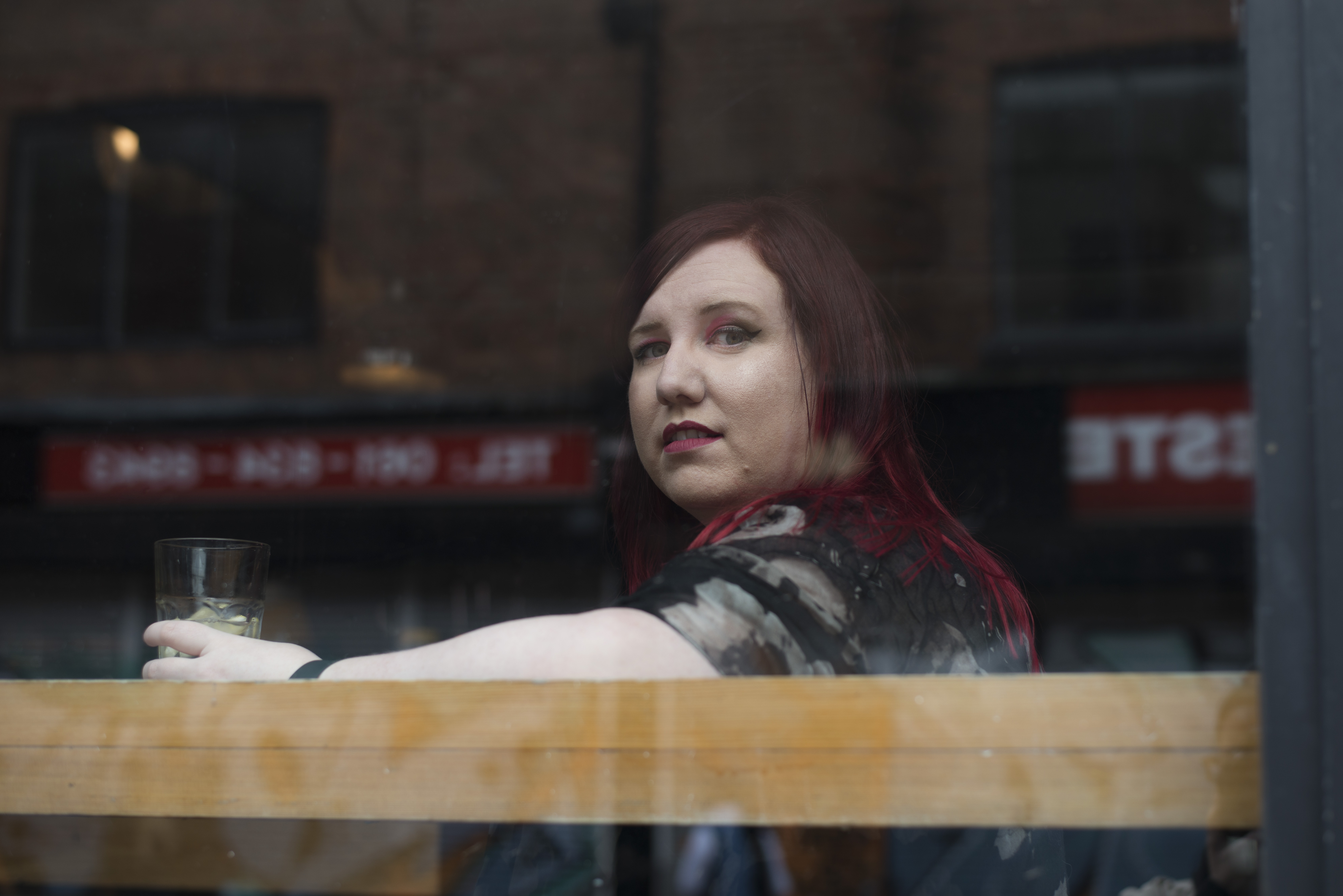 Lauren Hutchinson staring out through a window at a cafe