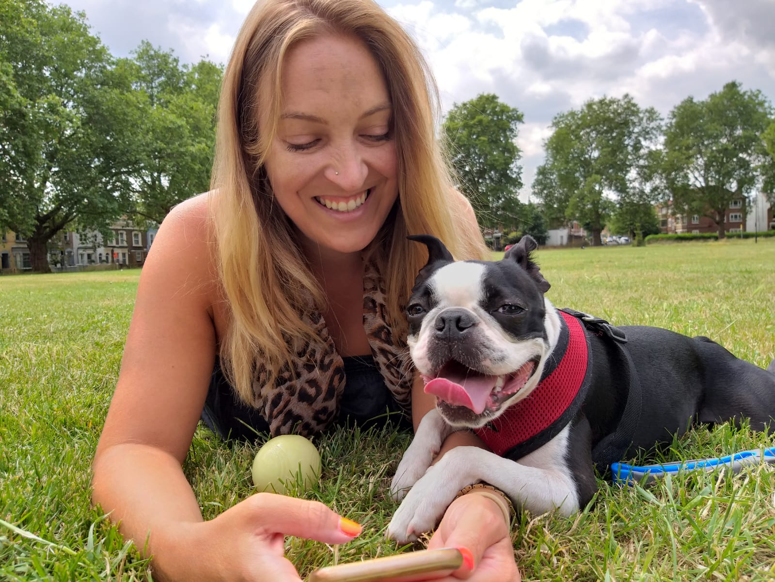 Sian Melonie lying on the grass with a dog