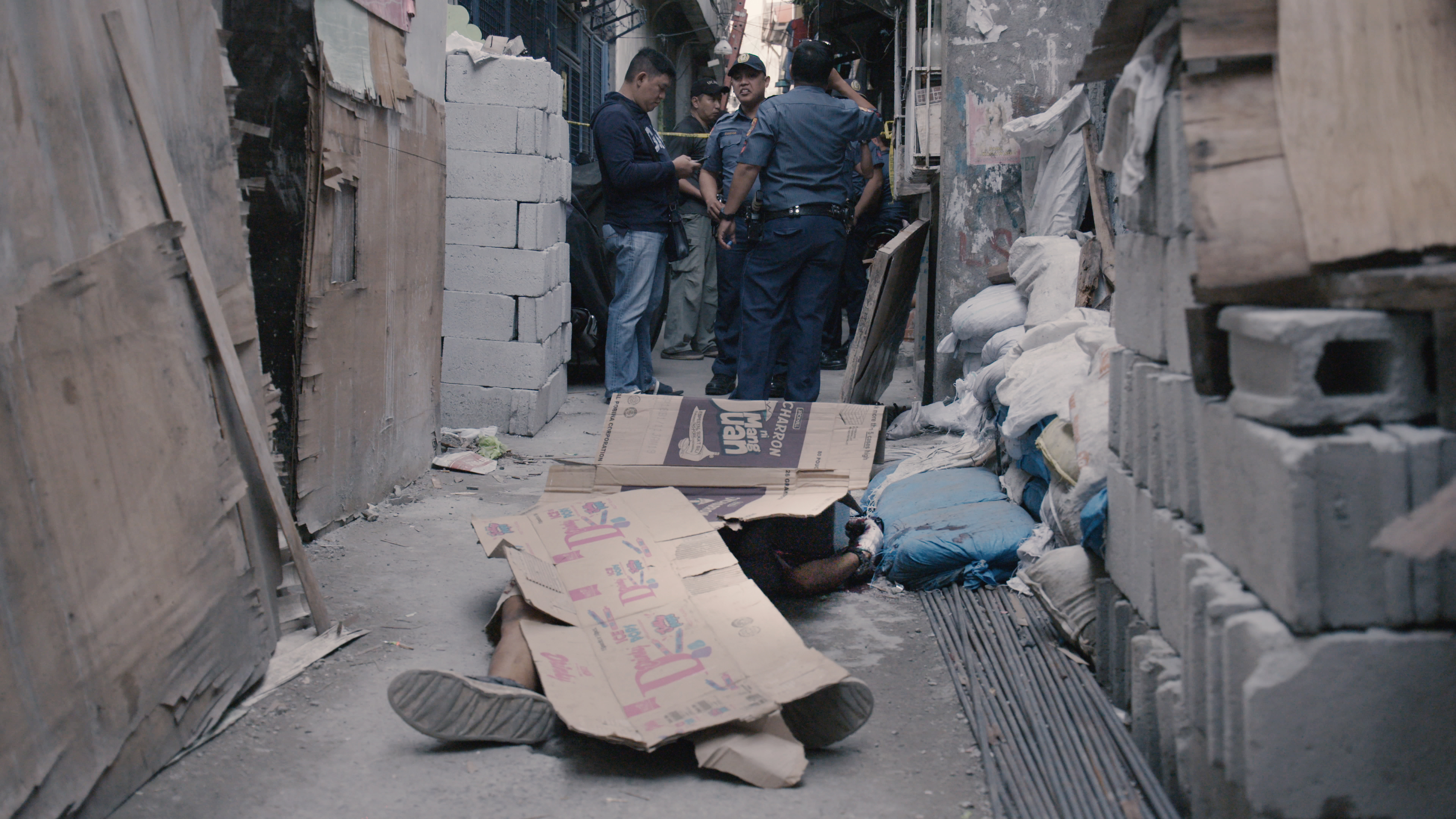 A body is covered with a cardboard box. Screenshot courtesy of