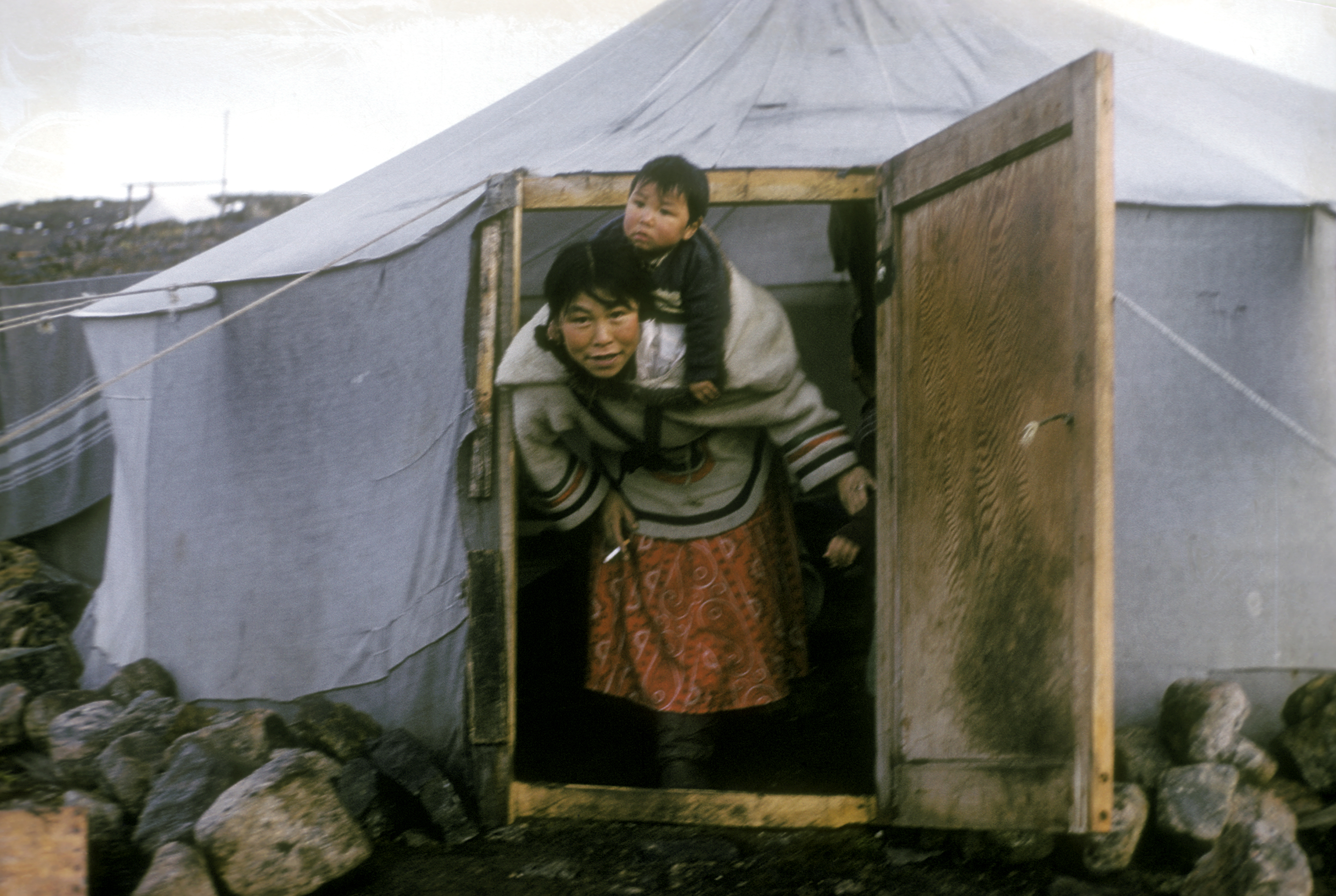 Kenojuak Ashevak, exits her tent with her son, Adamie Ashevak (Inuit), Cape Dorset, 1960. (Rosemary Eaton) © Libraries and Archives Canada
