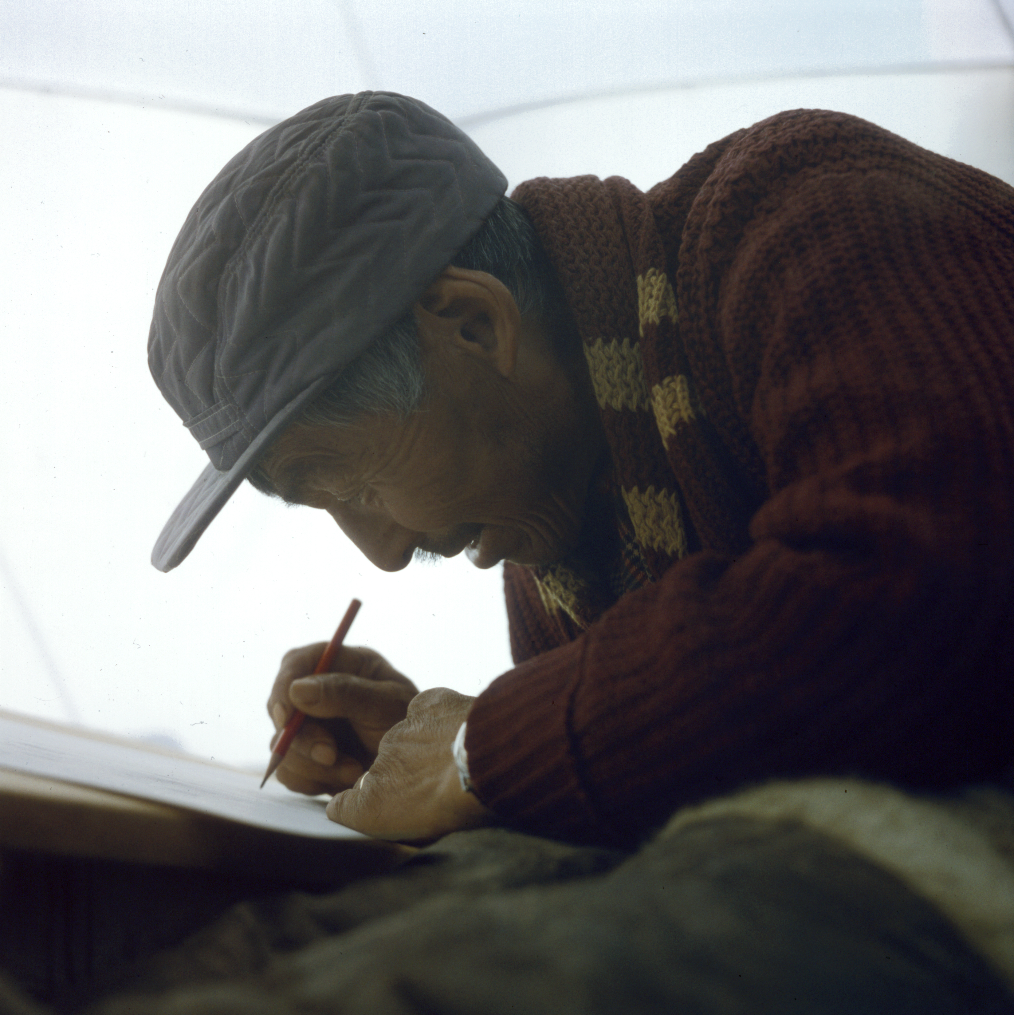 Artist Kiakshuk drawing in a tent, Cape Dorset, 1960. (Rosemary Eaton) © Libraries and Archives Canada