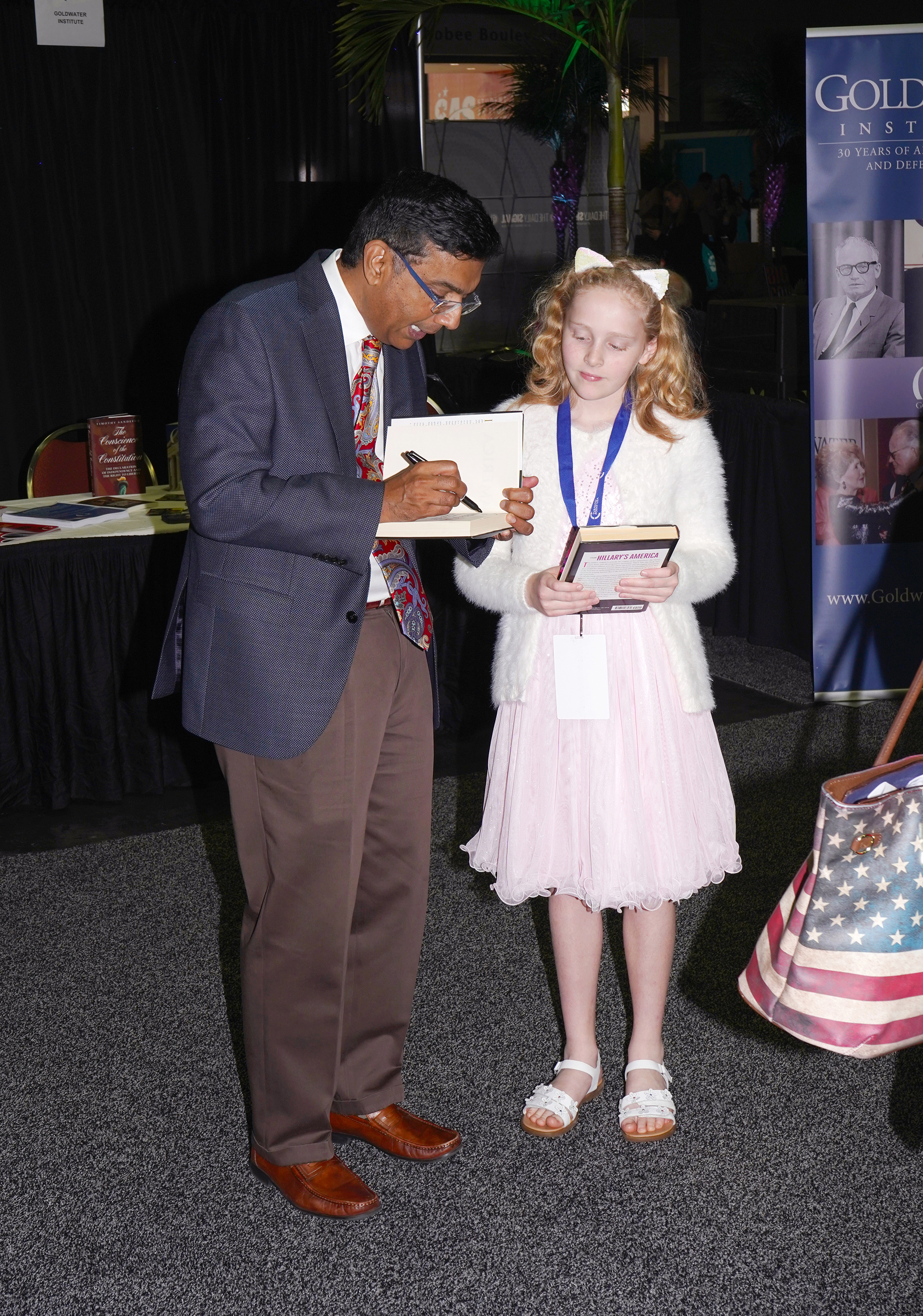 Dinesh D'Souza signs a book for a fan.