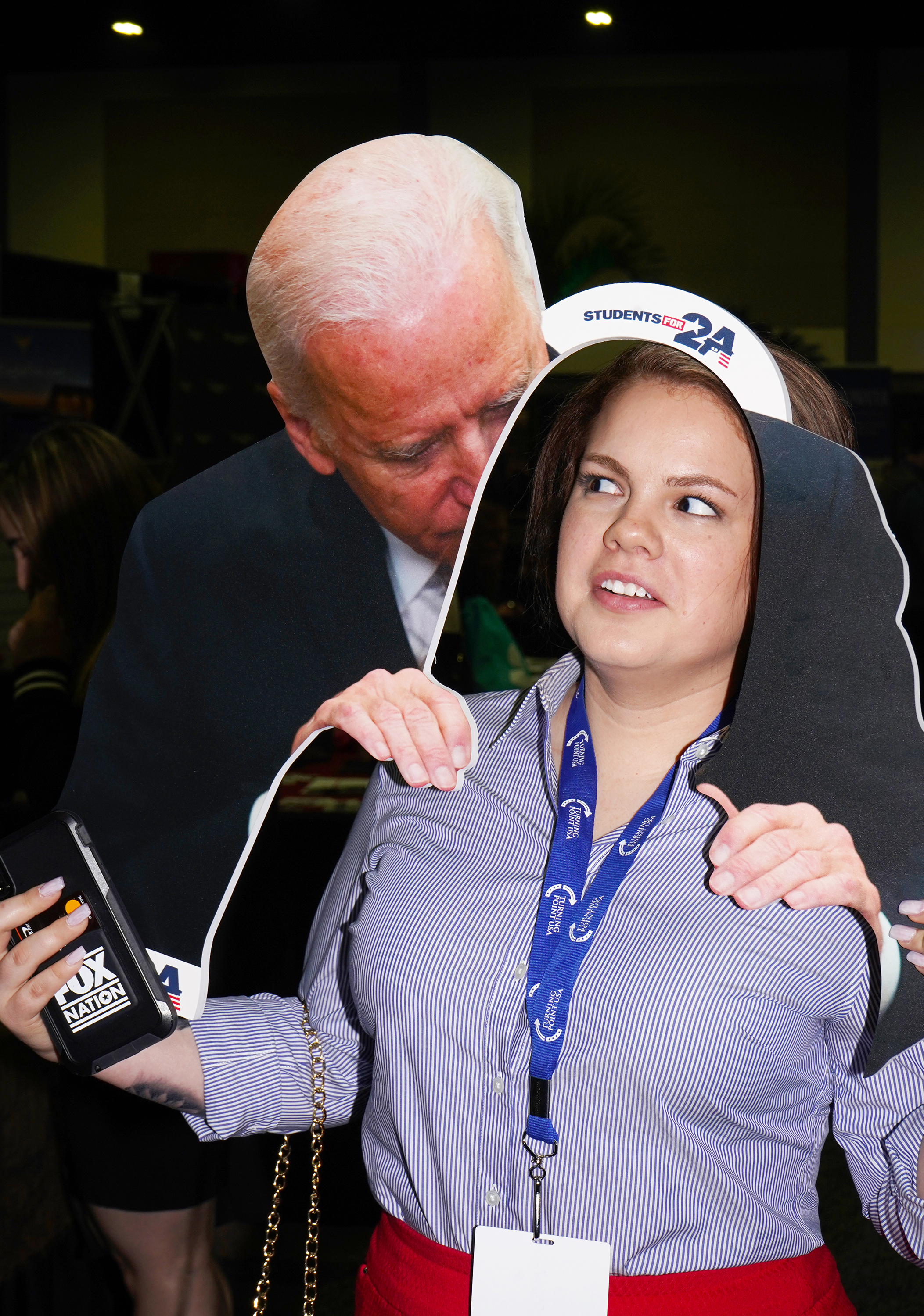 A woman next to a cardboard cutout of Joe Biden massaging her shoulders.
