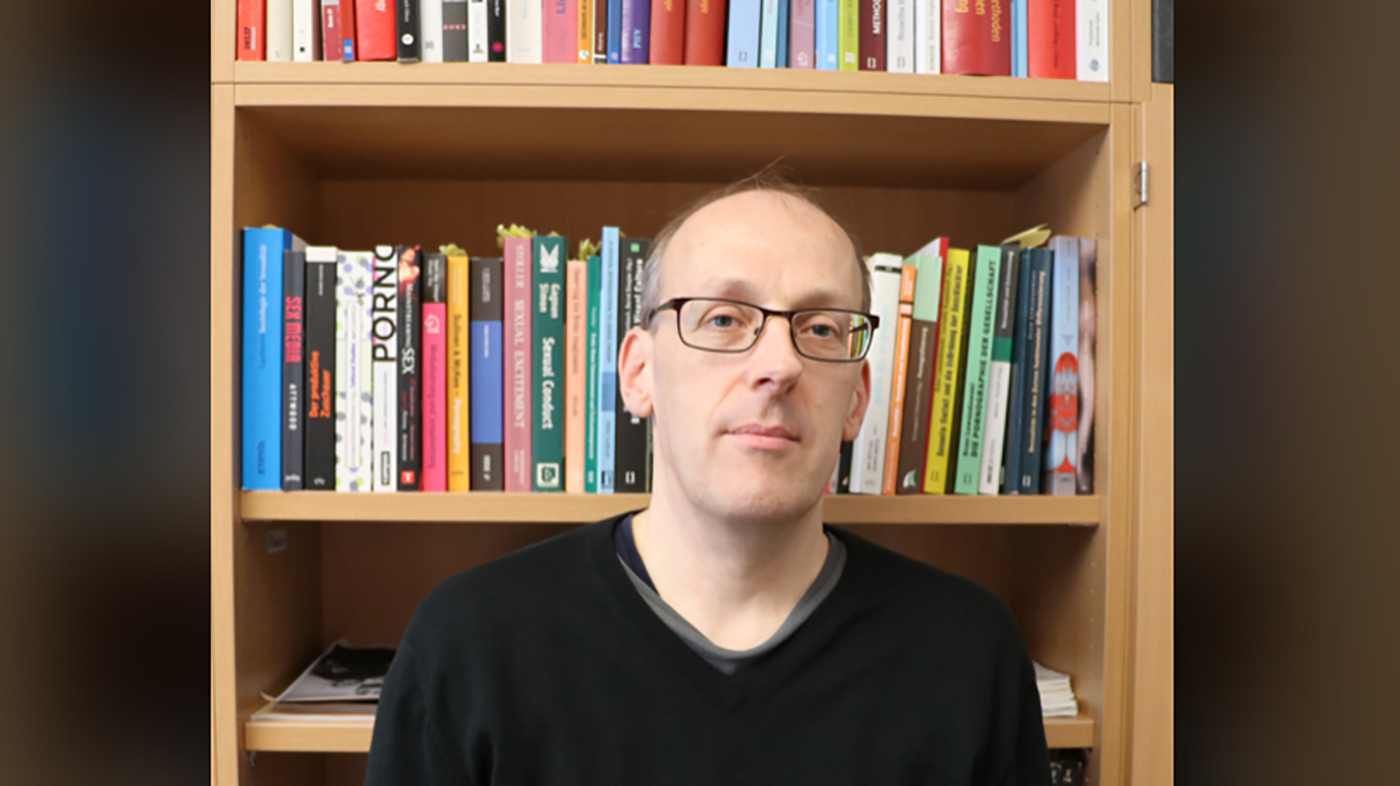 Sven Lewandowski vor einem Bücherregal