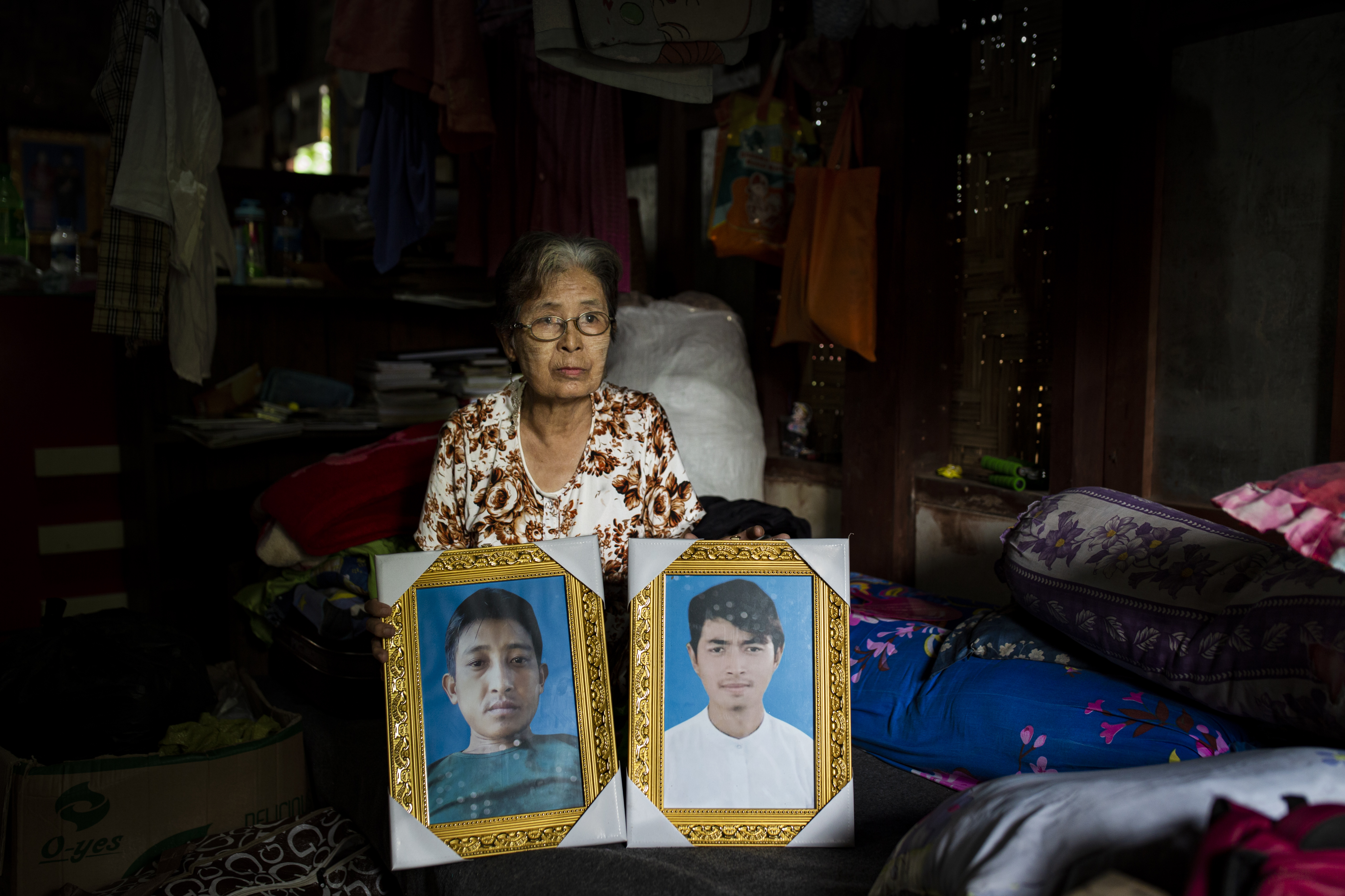 La-Ung Bawk Jan, 73, shows photos of her son-in-law, Nhkum La Di, and her grandson, Nhkum Awng Li, in her home in Myitkyina, Kachin State, Myanmar.