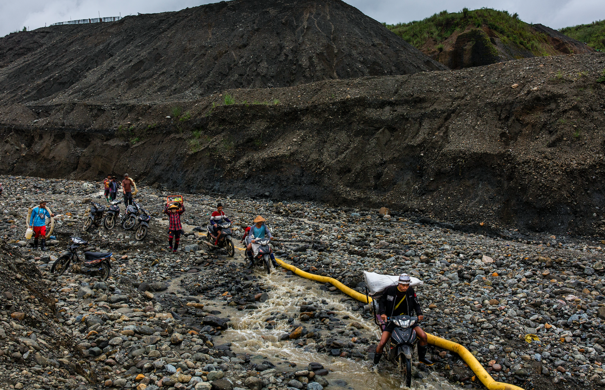 Freelance miners spray water out of pipes to clear dirt from stones in their search for jade. Taken in Hpakant, Kachin State, Myanmar on July 14, 2020.