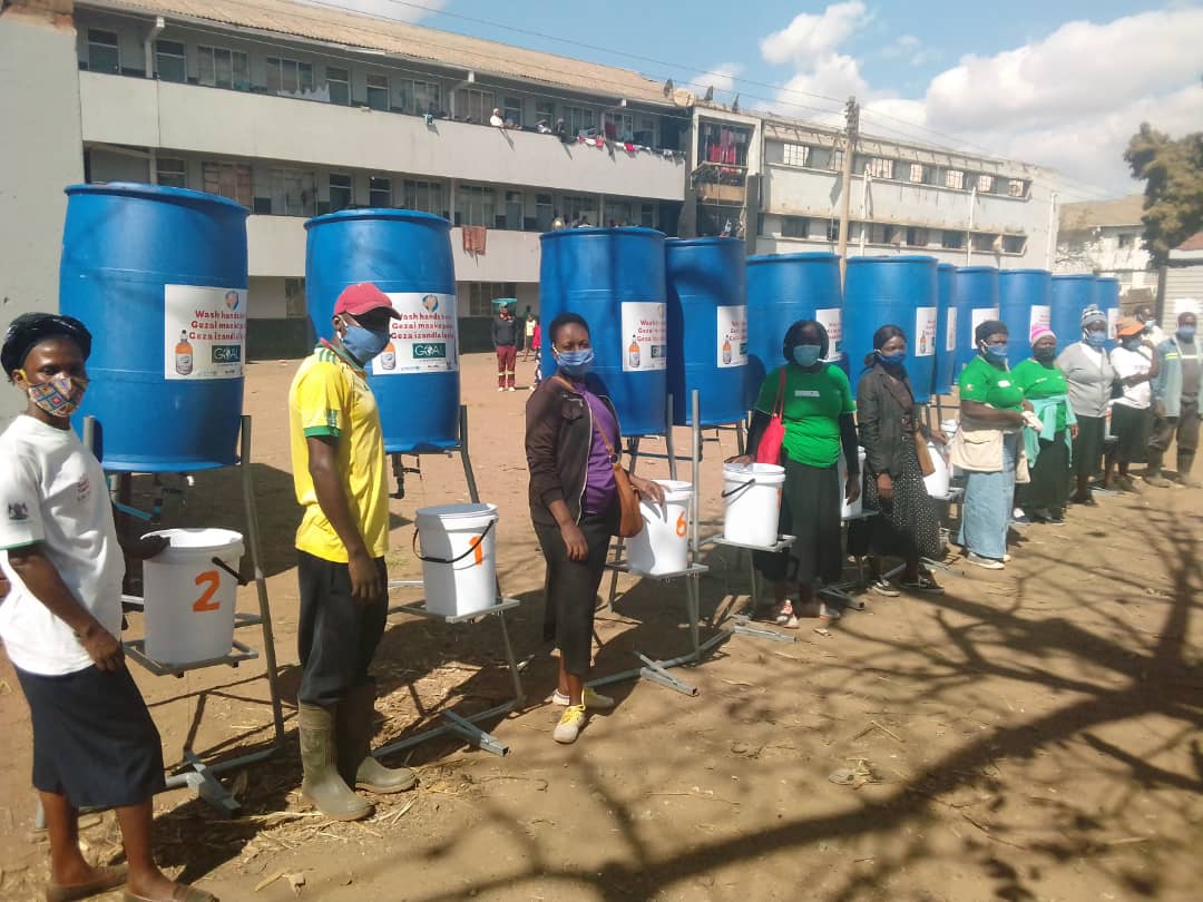 Residents line up at a communal borehole. 