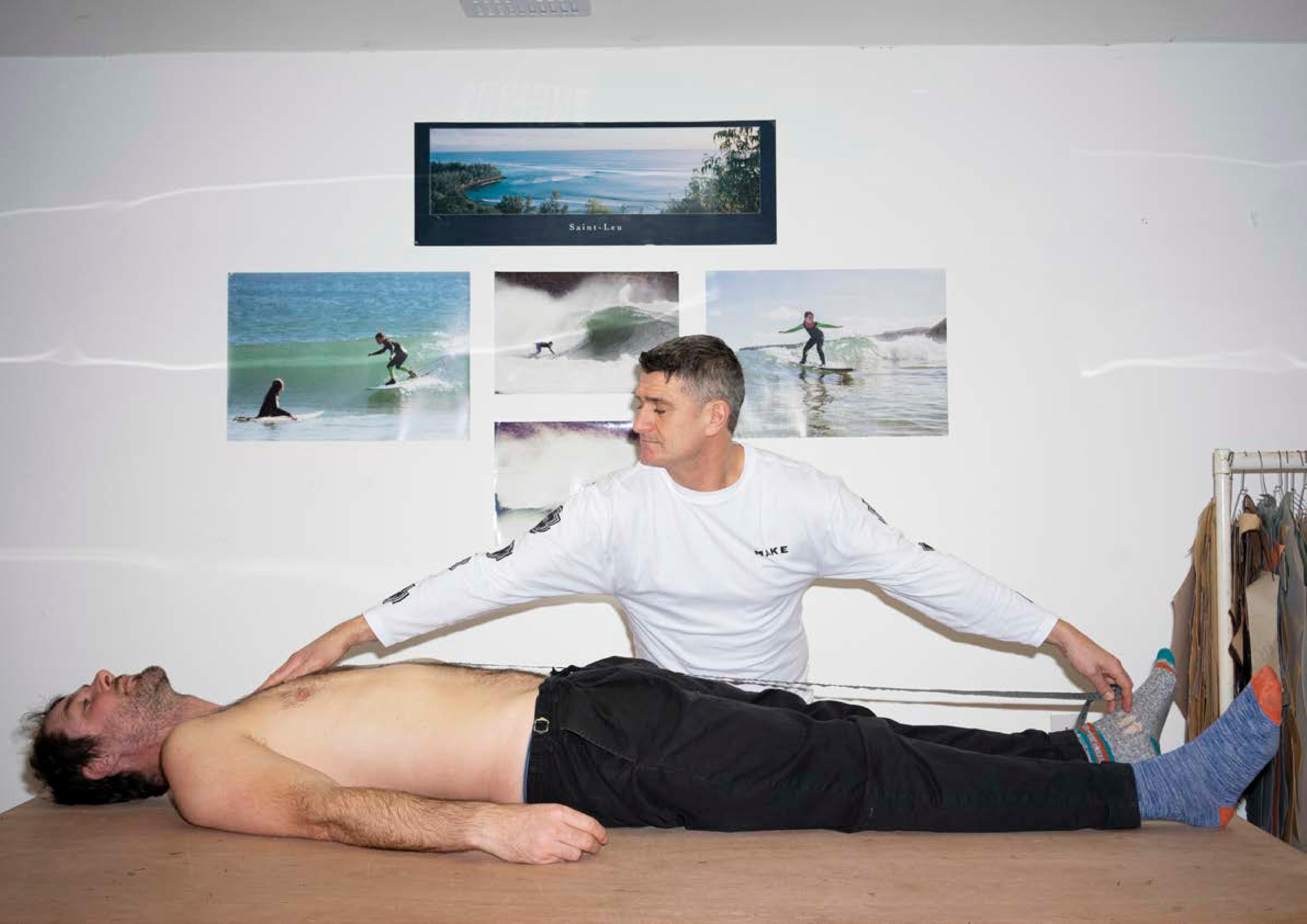 A man lying on a table being measured for a custom wetsuit