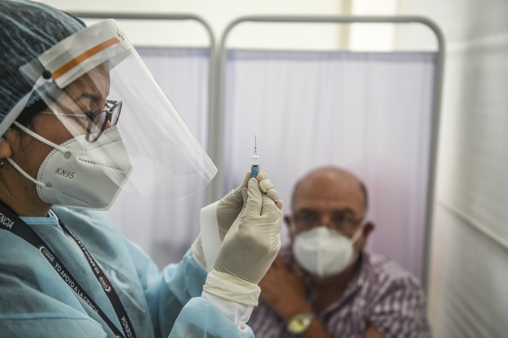 A health worker in Peru prepares a syringe with the Sinopharm vaccine during a hospital trial on Dec. 9, 2020. ERNESTO BENAVIDES / AFP