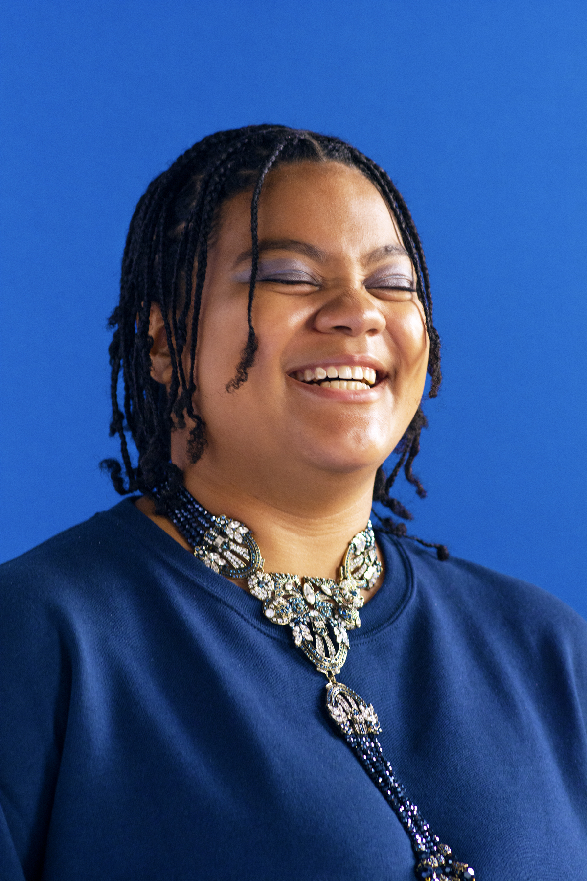 Woman in blue top and silver and blue beaded necklace. Photographed by Marcus Branch.