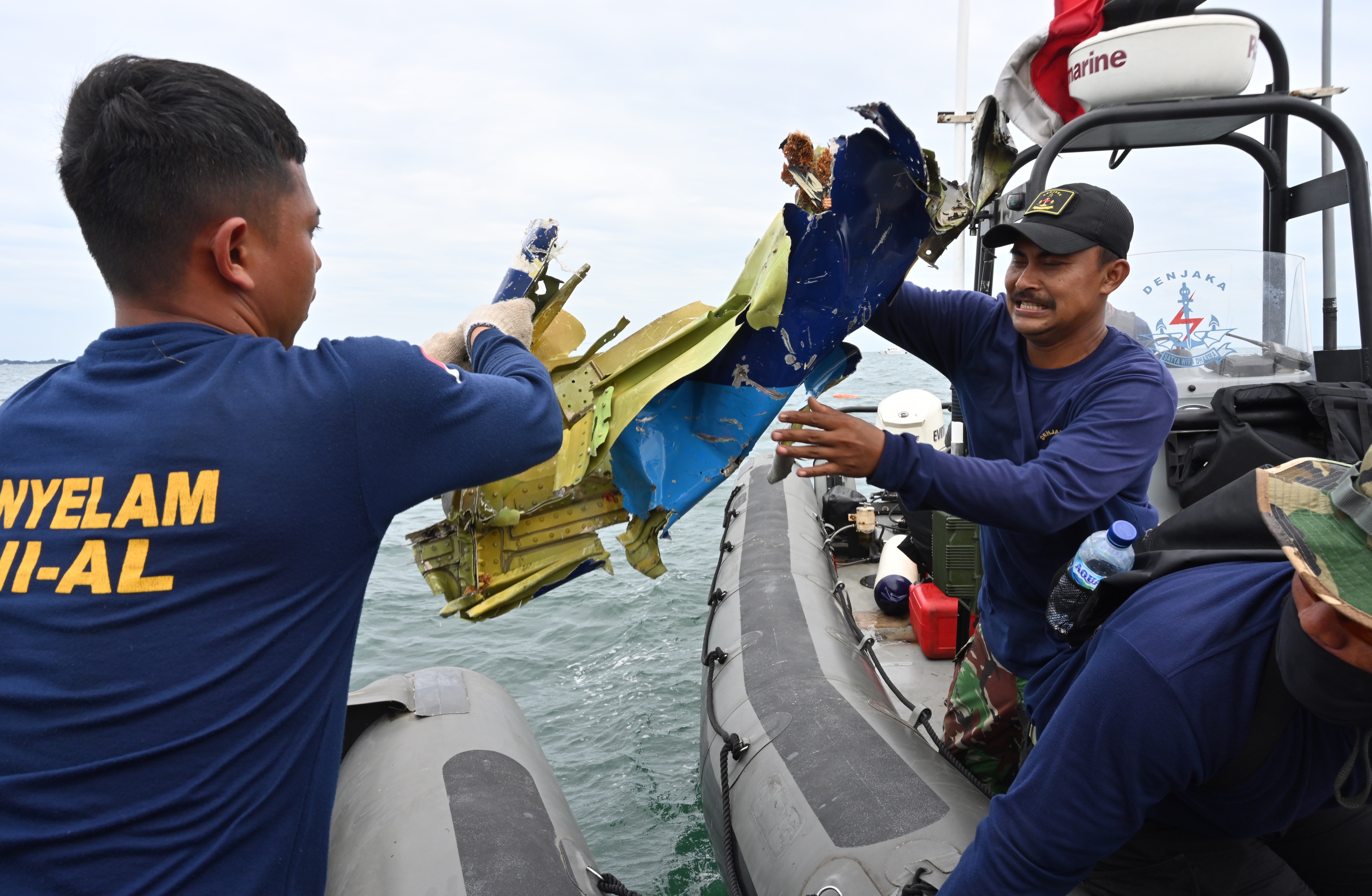 Navy divers retrieve wreckage near Lancang Island. (AFP PHOTO BY ADEK BERRY)