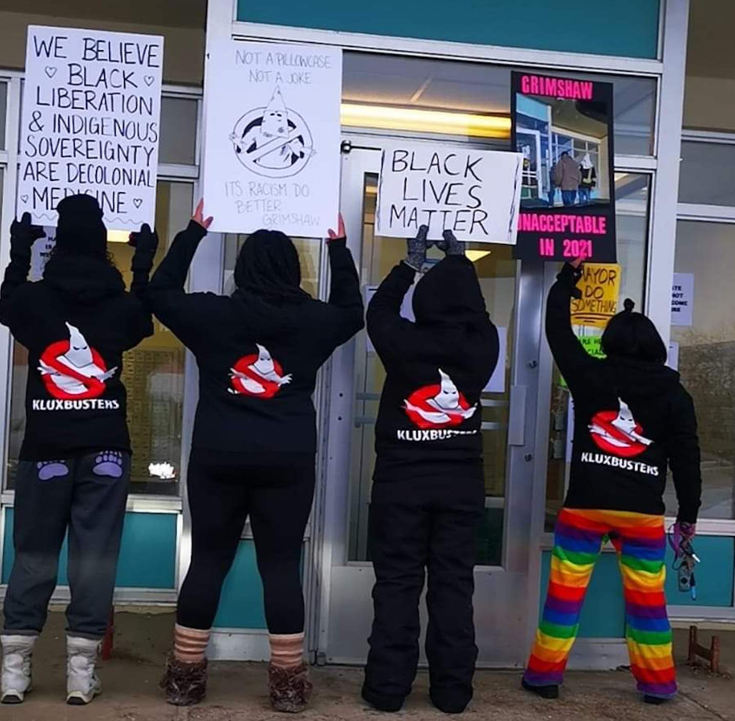 Members of Alberta Humanitarian Initiative protest outside Grimsby's post office where a man wearing a KKK-style hood was spotted.