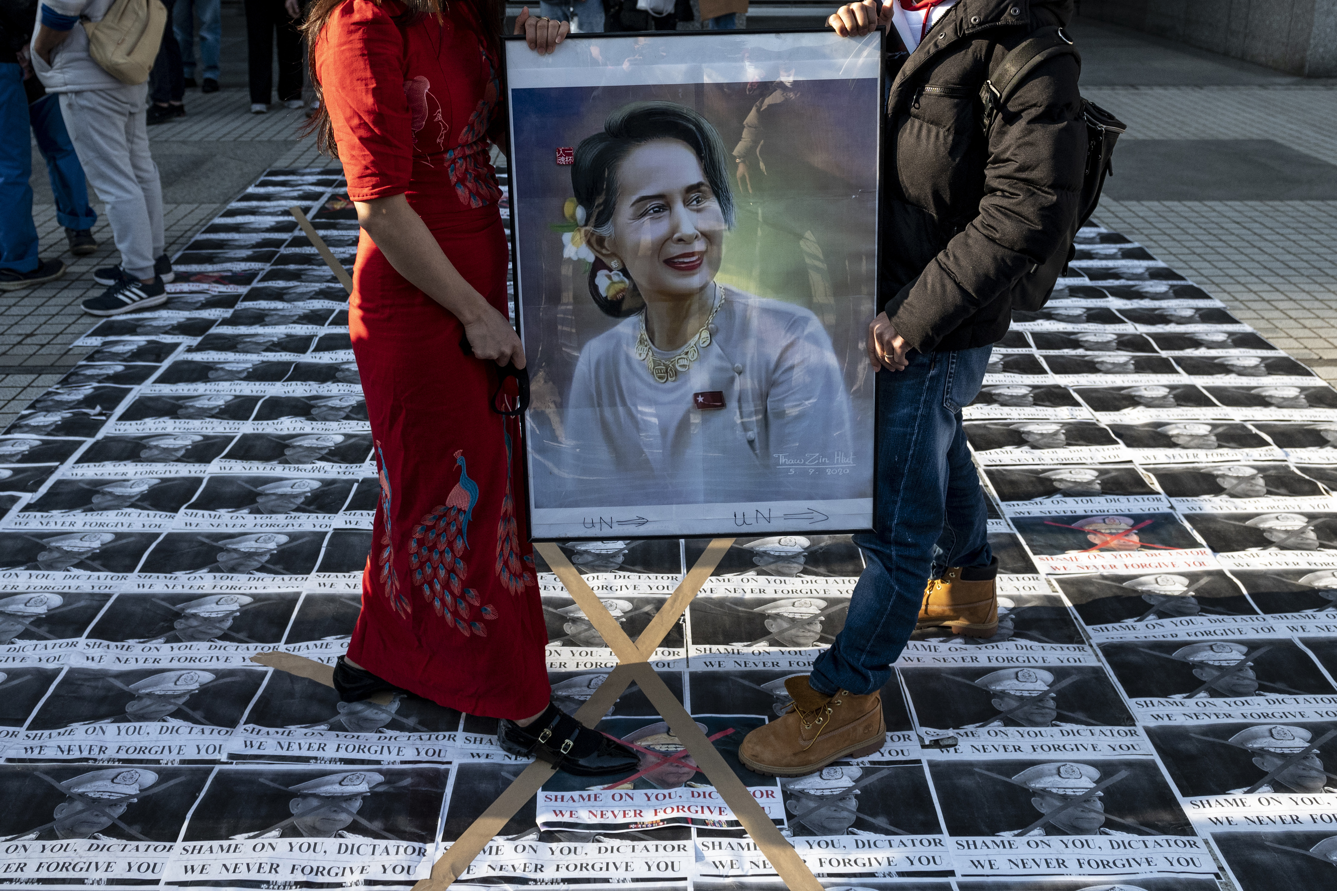 Activists hold a portrait of Myanmar's de facto leader Aung San Suu Kyi while standing on portraits of the country's military general Min Aung Hlaing during a protest outside the United Nations University building in Tokyo on Feb. 1, 2021, after Myanmar's military seized power in a bloodless coup and detaining democratically elected leader Aung San Suu Kyi as it imposed a one-year state of emergency. PHOTO: Philip FONG / AFP