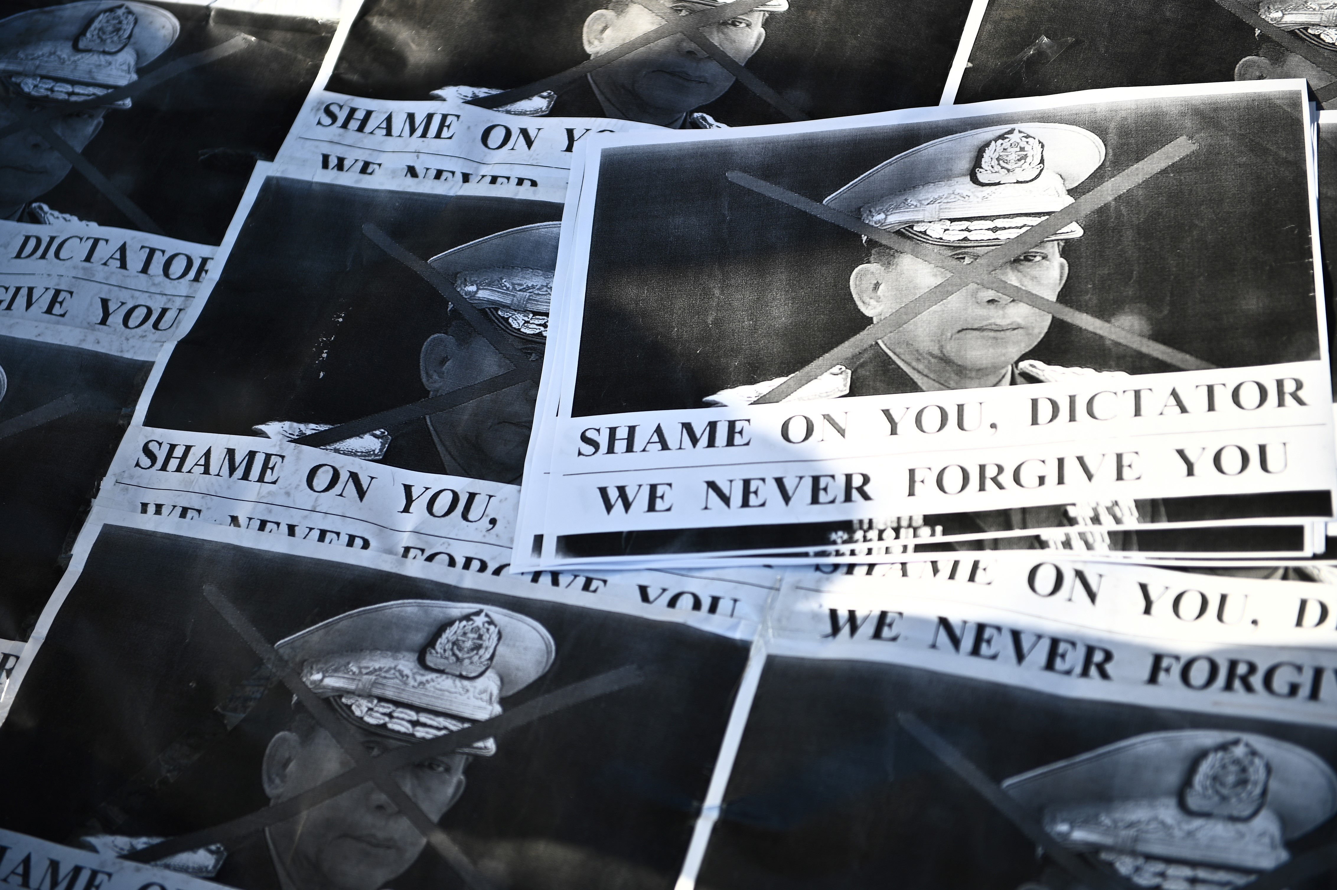 Images of Myanmar's military chief General Min Aung Hlaing are pictured as a group of Myanmar activists protest outside United Nations University building in Tokyo on Feb. 1, 2021, following a military coup in the country after arresting civilian leader Aung San Suu Kyi and other senior officials. Philip FONG / AFP