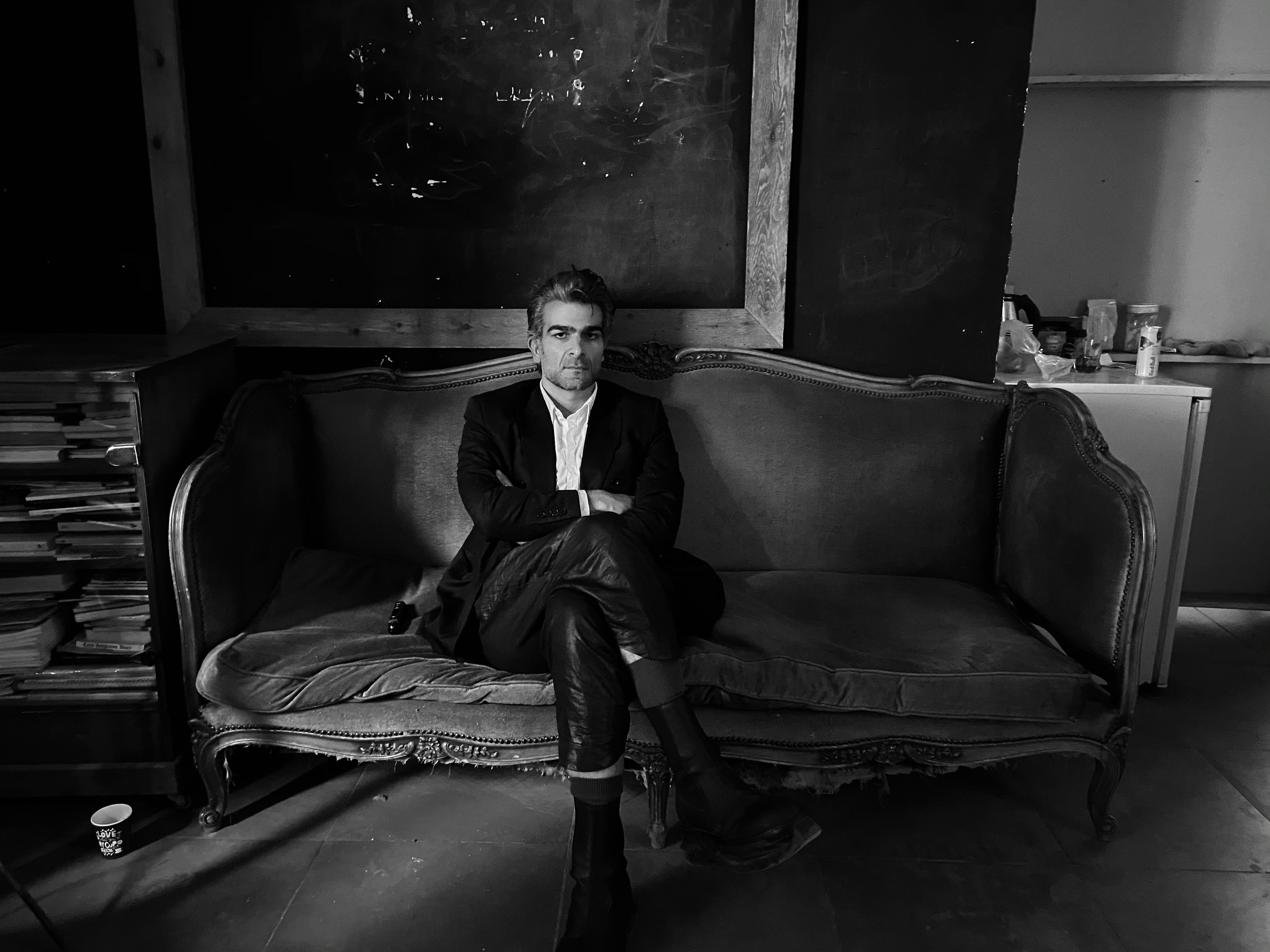 Kegham Djeghalian, art director – portrait of a man with short hair and a beard wearing a suit and sitting on an antique couch.
