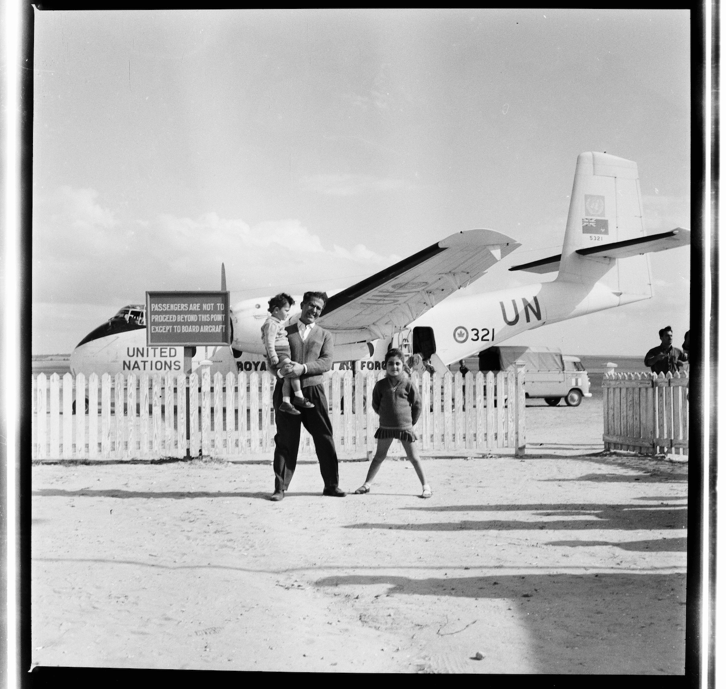 Kegham Djeghalian, Gaza photographer – A man holding a child and posing with his daughter in front of a UN plane.