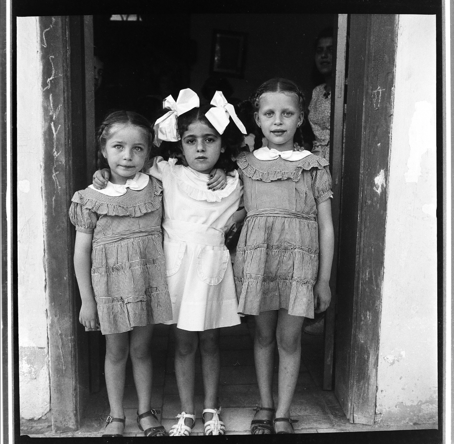 Kegham Djeghalian, Gaza photographer – Three young girls in vintage frilly dresses and sandals posing together. 