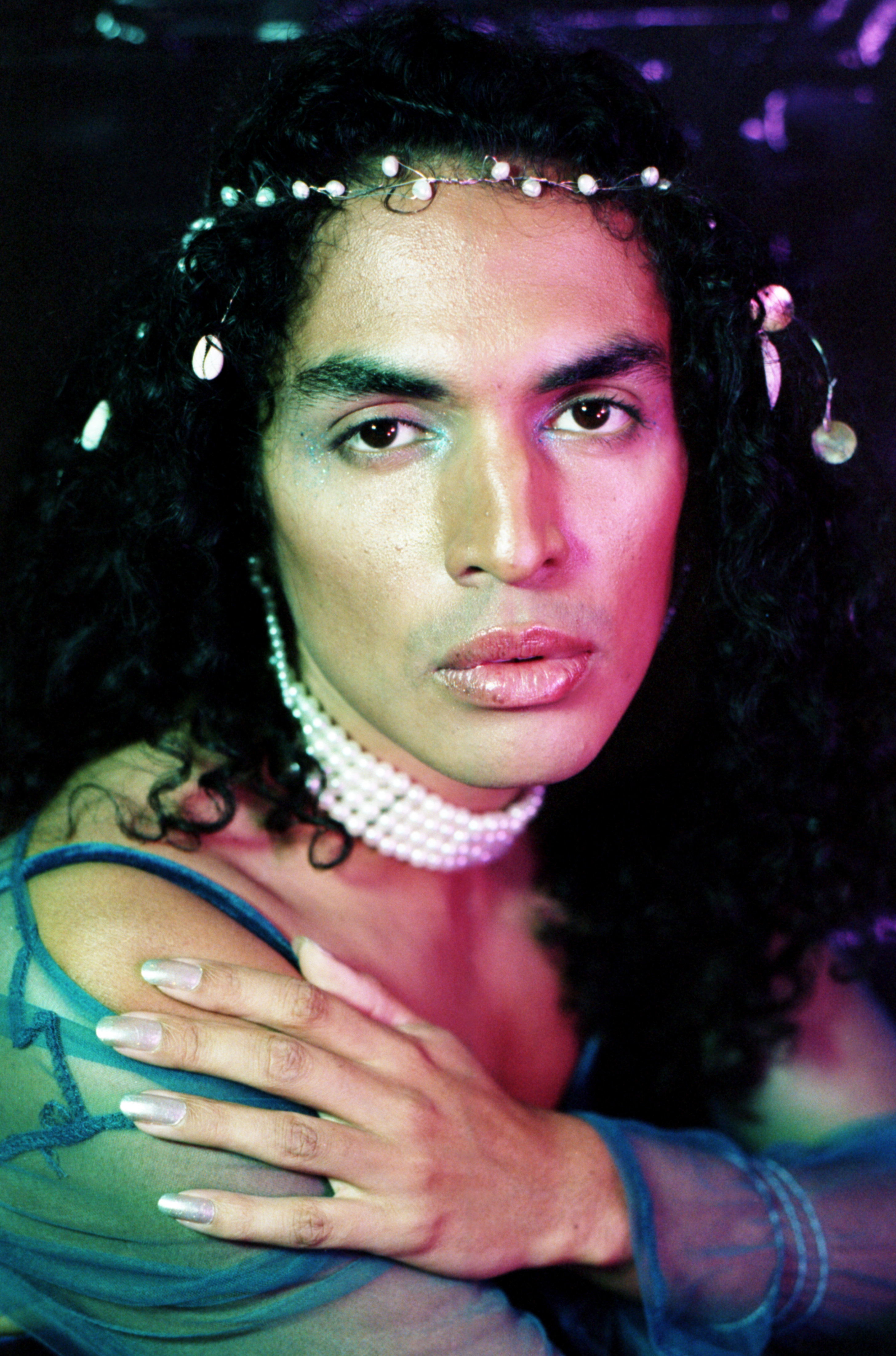 Siren con vestito azzurro, coroncina nei capelli e collana di perle, progetto Show Me Your Queer