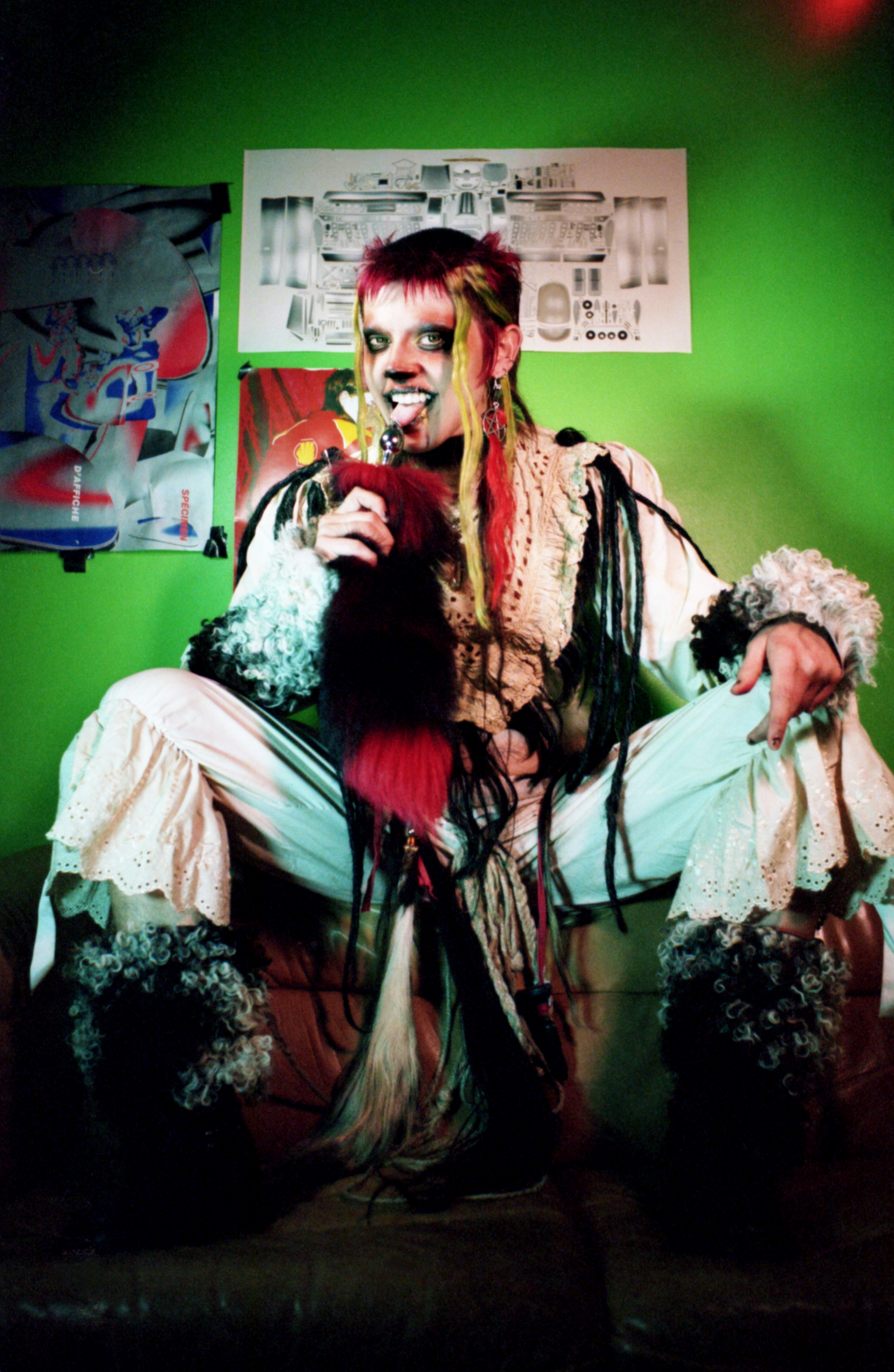 Levi sul divano con pellicia davanti a una parete verde acido, progetto Show Me Your Queer