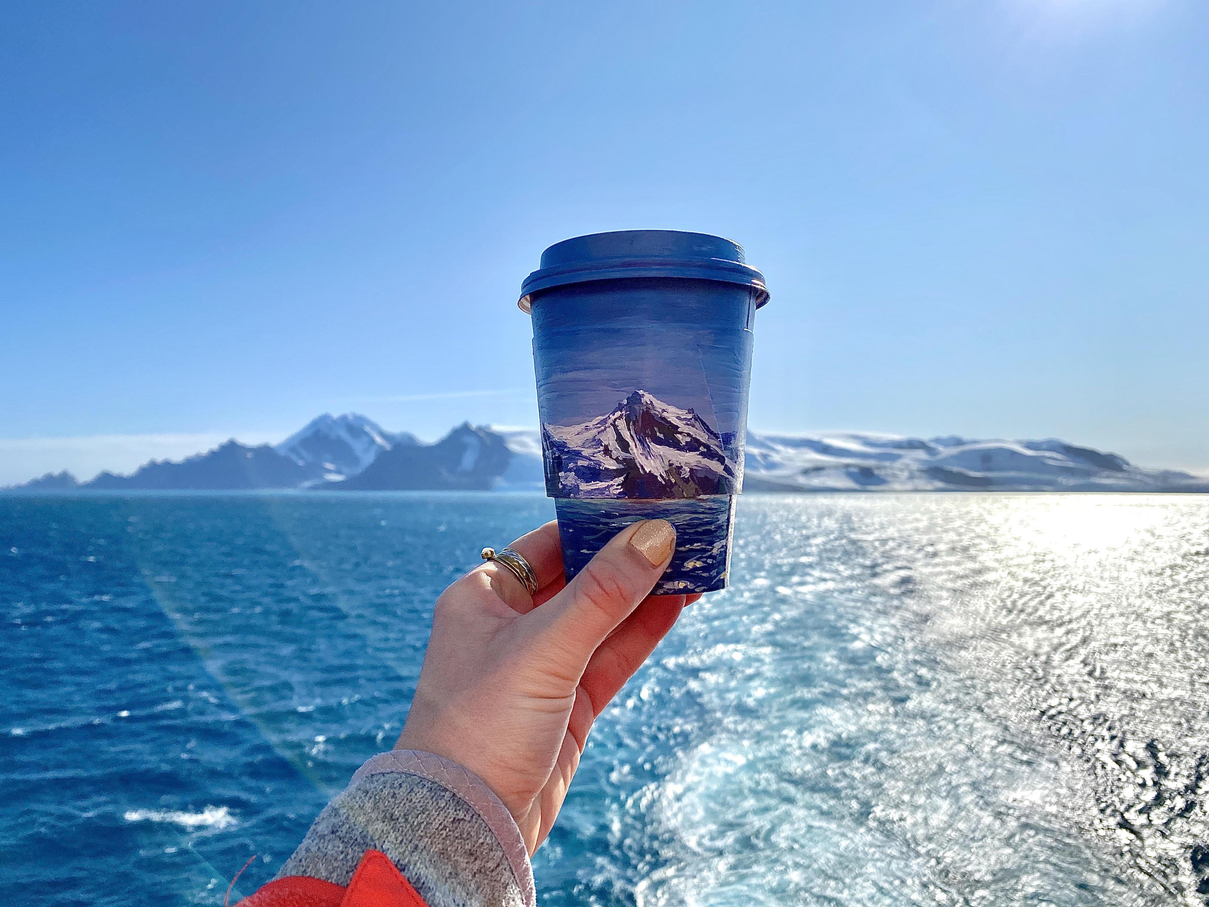 Lukisan laut dan gunung es Antartika pada cangkir kopi