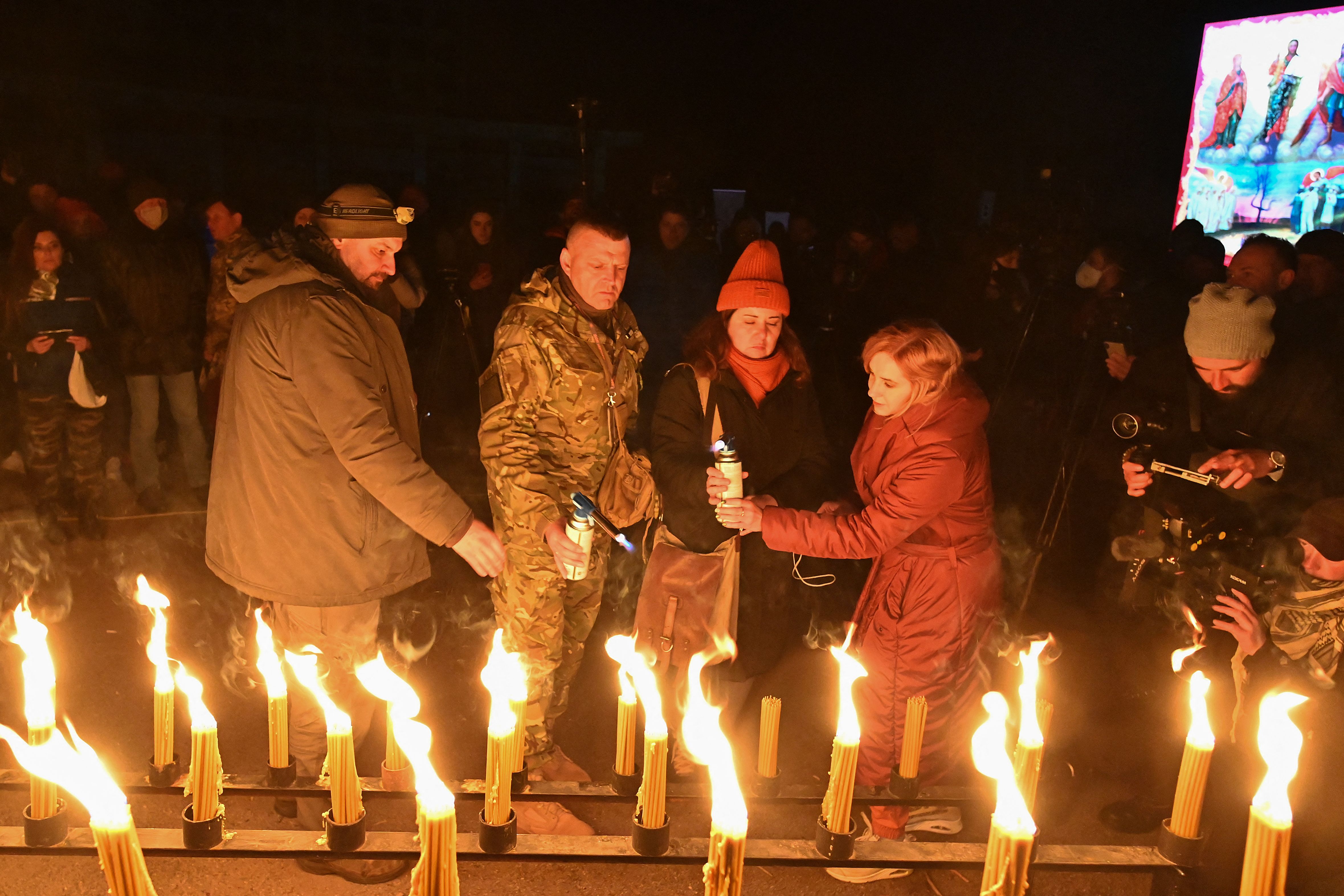 Warga menyalakan lilin di alun-alun pusat kota Pripyat. Foto: Genya Savilov/AFP