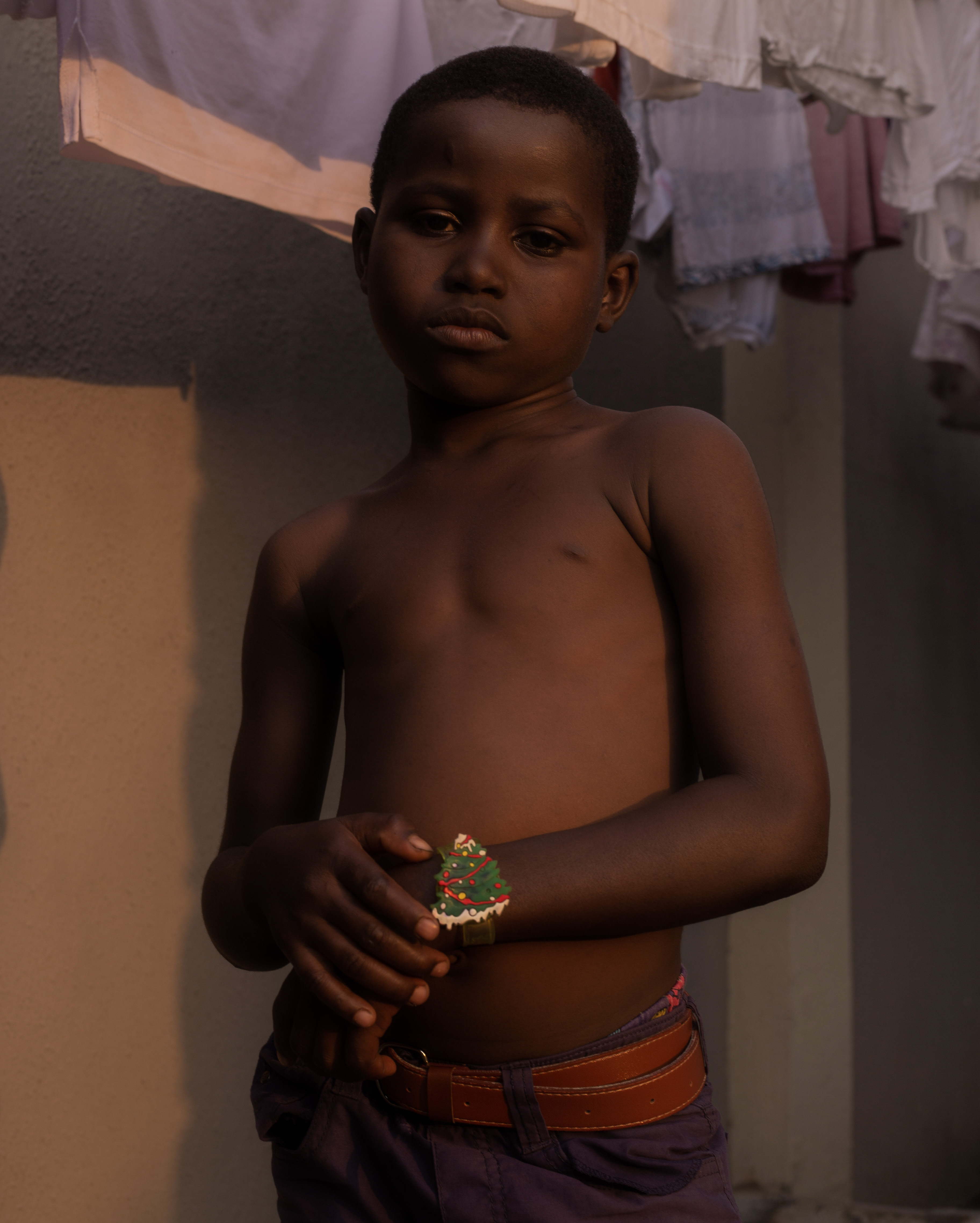 a young boy shows off his christmas tree bracelet