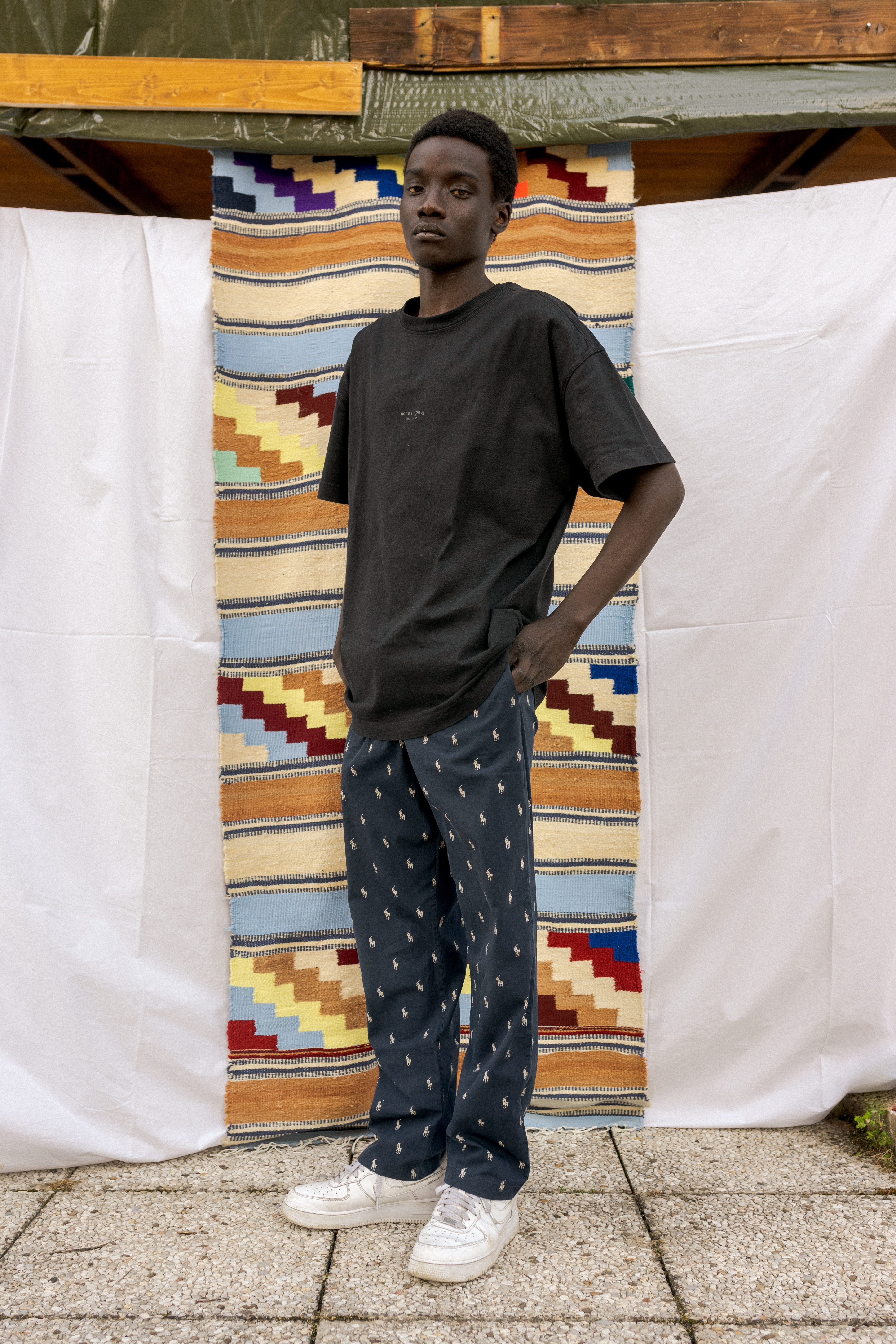 YOUTH-Torino, l'editoriale di i-D sui ragazzi di seconda generazione: Malik King figura intera davanti ad un tappeto,