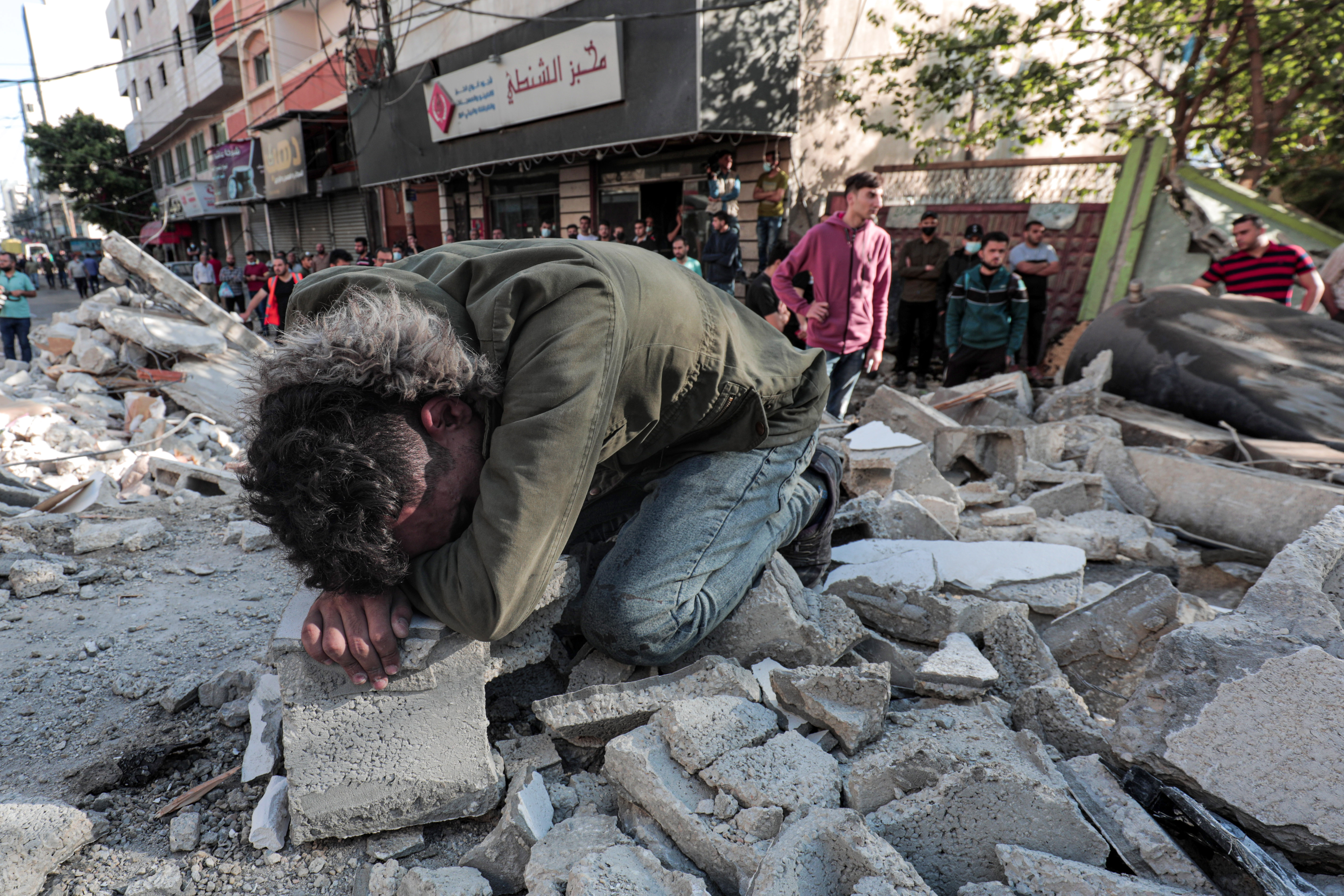 A Palestinian man weeps after victims of an Israeli air raid were removed from beneath the rubble of a destroyed home. Photo: Momen Faiz/NurPhoto via Getty Images